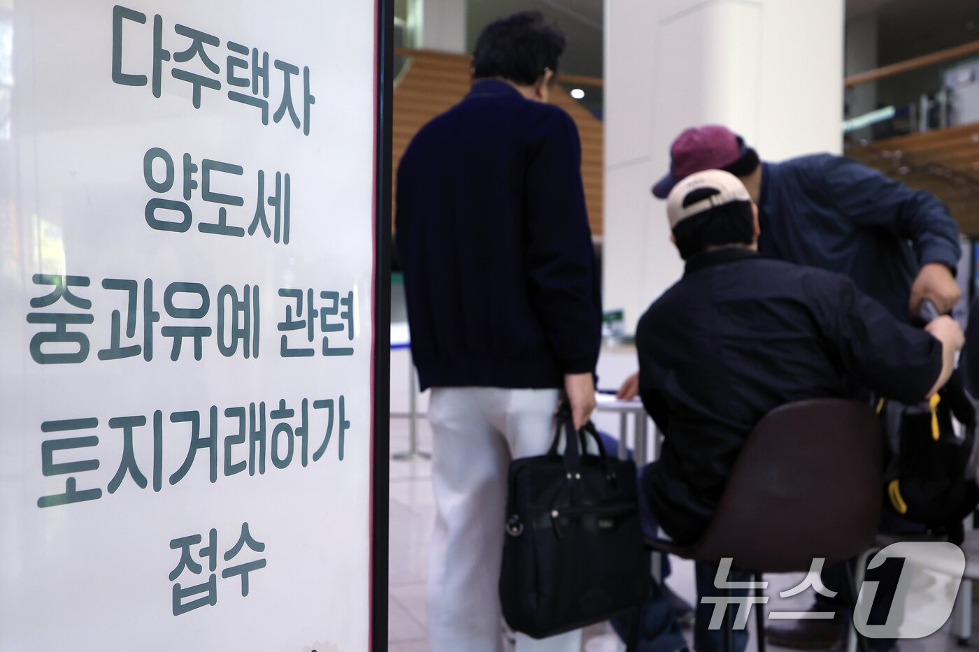 본문 이미지 - 다주택자 양도소득세 중과 유예 종료 시한인 5월 9일 오전 서울시 송파구 송파구청 1층에 마련된 다주택자 양도세 중과유예 관련 토지거래허가 접수처를 찾은 시민들이 부동산정보과 공무원들에게 서류 검토를 받고 있다. ⓒ 뉴스1 박정호 기자
