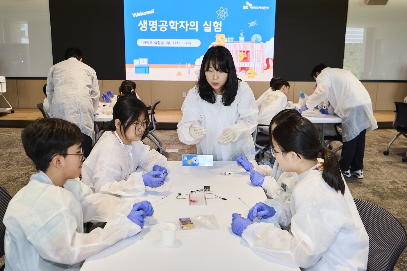 본문 이미지 - 체험 프로그램 '바이오실험실'에 참가한 구성원 가족 어린이들이 DNA 분석 실험을 진행하고 있다. (SK바이오사이언스 제공)