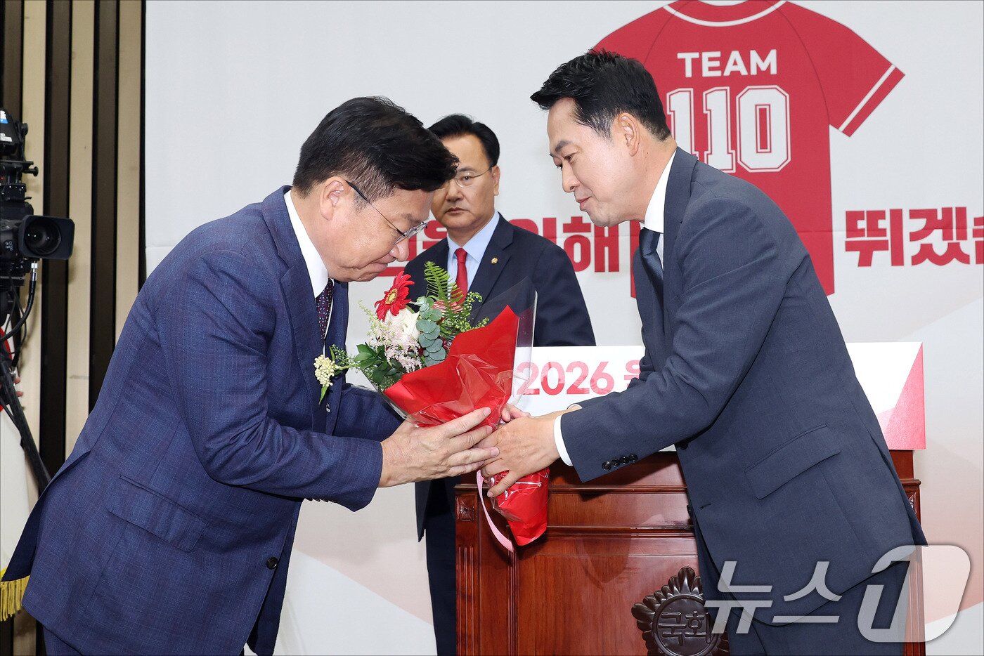 본문 이미지 - 장동혁 국민의힘 대표가 10일 서울 여의도 국회에서 열린 국민의힘 원내대표 선출 의원총회에서 정점식 신임 원내대표에게 꽃다발을 전달하고 있다. (공동취재) 2026.6.10 ⓒ 뉴스1 신웅수 기자