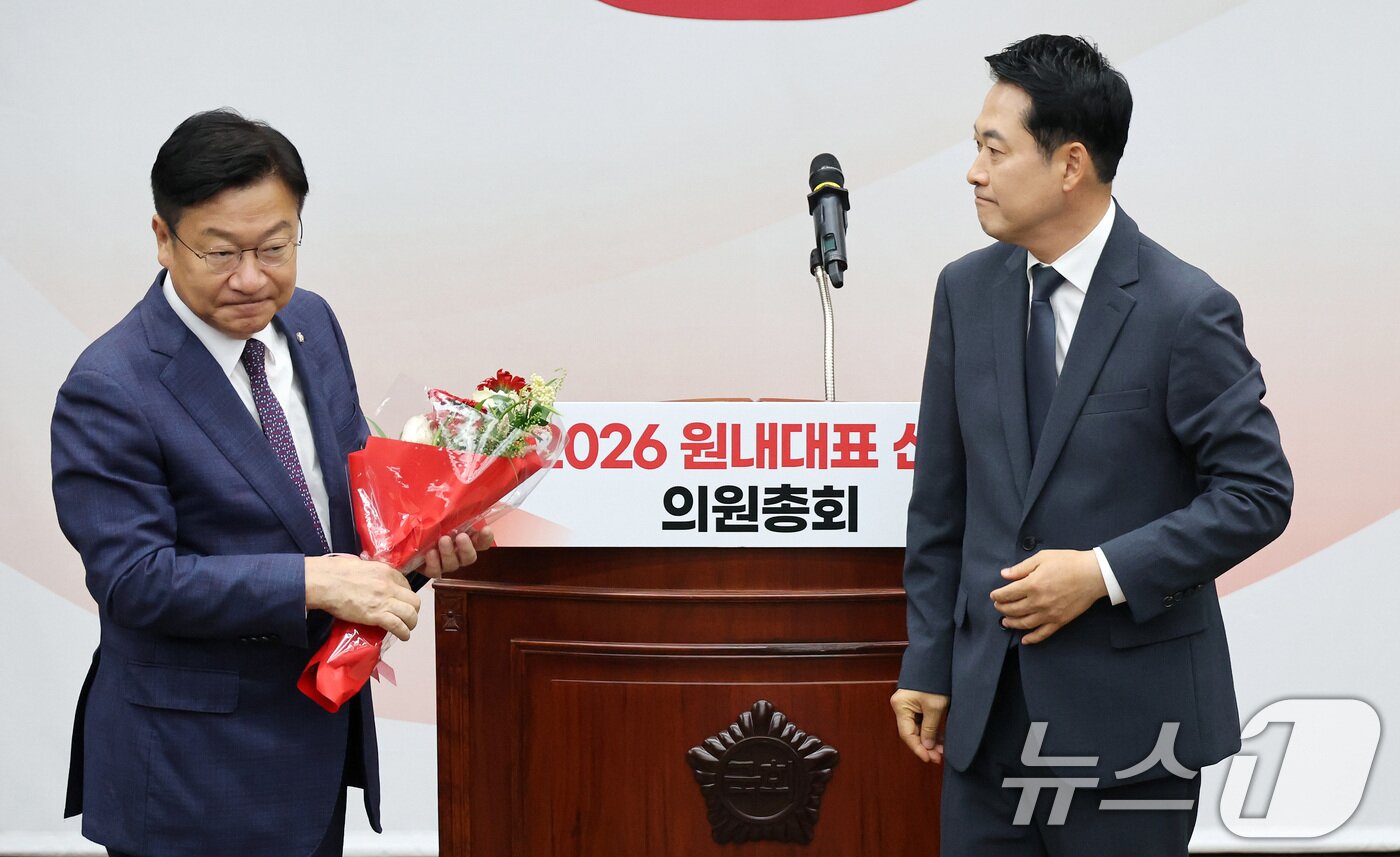 본문 이미지 - 장동혁 국민의힘 대표가 10일 서울 여의도 국회에서 열린 국민의힘 원내대표 선출 의원총회에서 정점식 신임 원내대표에게 꽃다발을 전달하고 있다. (공동취재) 2026.6.10 ⓒ 뉴스1 신웅수 기자