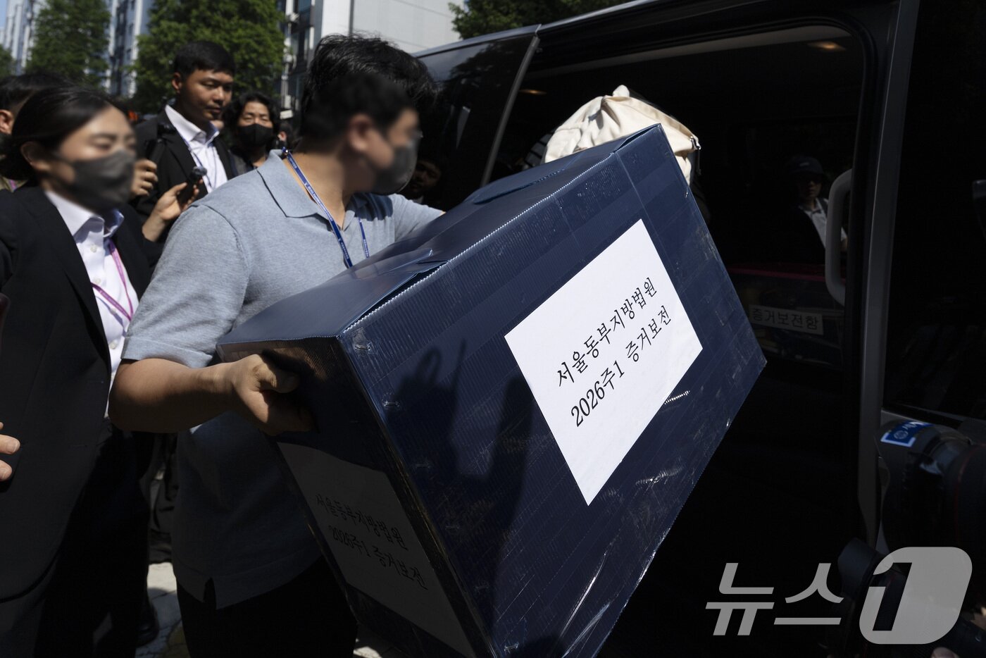 본문 이미지 - 김지연 서울동부지방법원 부장판사와 관계자들이 10일 오후 6·3 지방선거 투표용지 부족 사태가 발생한 잠실7동 제2투표소였던 서울 송파구 우성아파트 노인정의 현장 검증을 마친 뒤 증거물을 들고 차량에 오르고 있다. (공동취재) 2026.6.10 ⓒ 뉴스1 최지환 기자