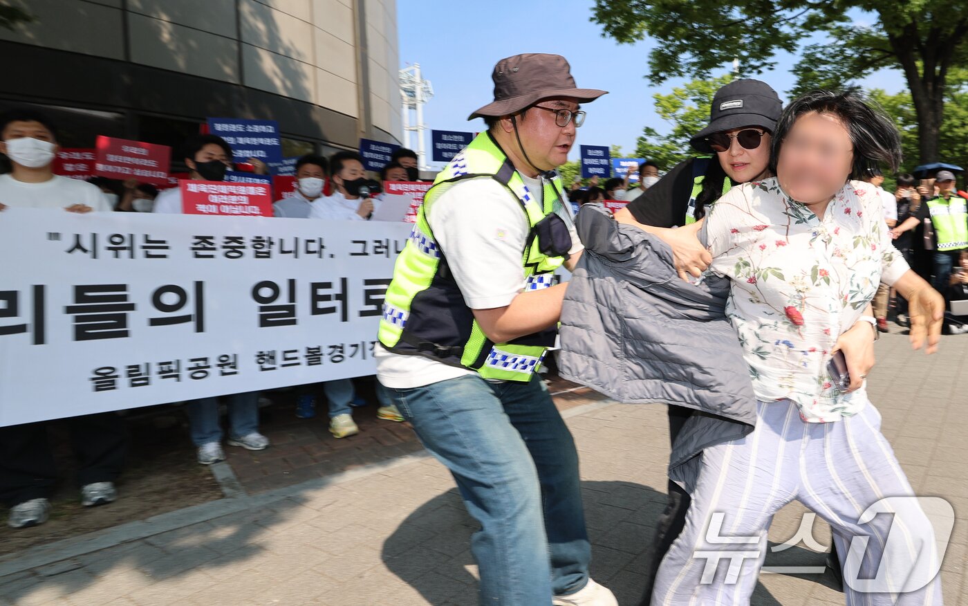 본문 이미지 - 11일 서울 송파구 올림픽공원 핸드볼경기장 앞에서 열린 핸드볼경기장 입주 체육단체 직원들의 업무 정상화 호소문 발표 기자회견 도중 한 여성이 기자회견을 가로막으며 항의하고 있다. 2026.6.11 ⓒ 뉴스1 오대일 기자