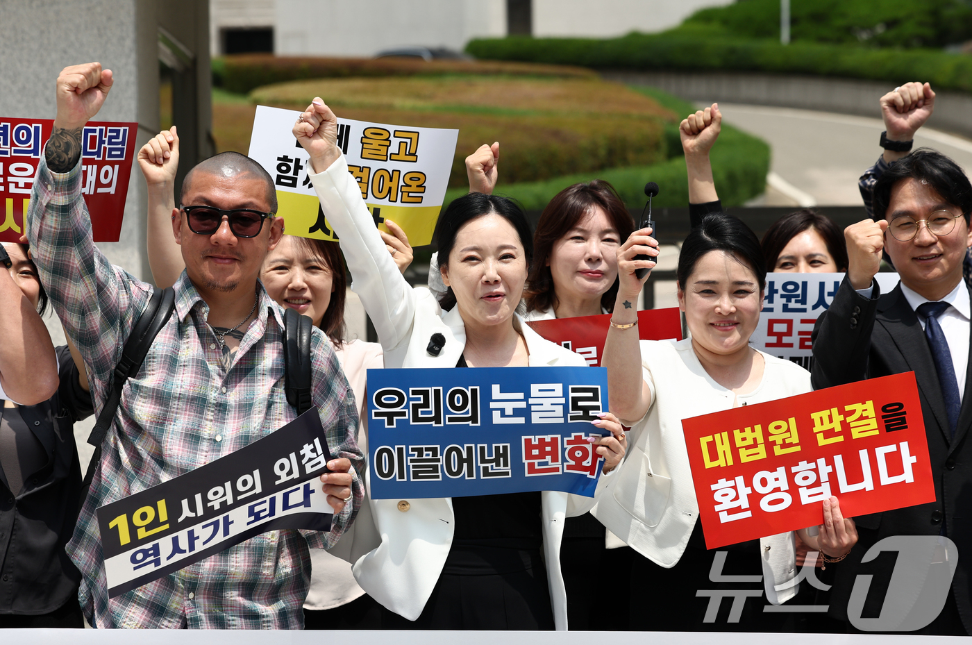(서울=뉴스1) 최지환 기자 = 임보란 대한문신사중앙회 회장과 사건 당사자 등 관계자들이 11일 서울 서초구 대법원 앞에서 대법원의 문신 사건 무죄 확정 관련 기자회견에서 기뻐하고 …