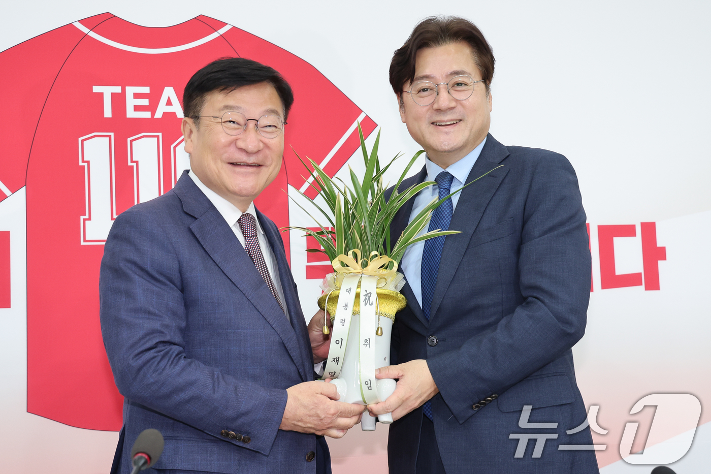 (서울=뉴스1) 안은나 기자 = 정점식 국민의힘 원내대표(왼쪽)가 11일 오후 서울 여의도 국회에서 홍익표 대통령비서실 정무수석으로부터 이재명 대통령 명의 축하 난을 받고 있다. …