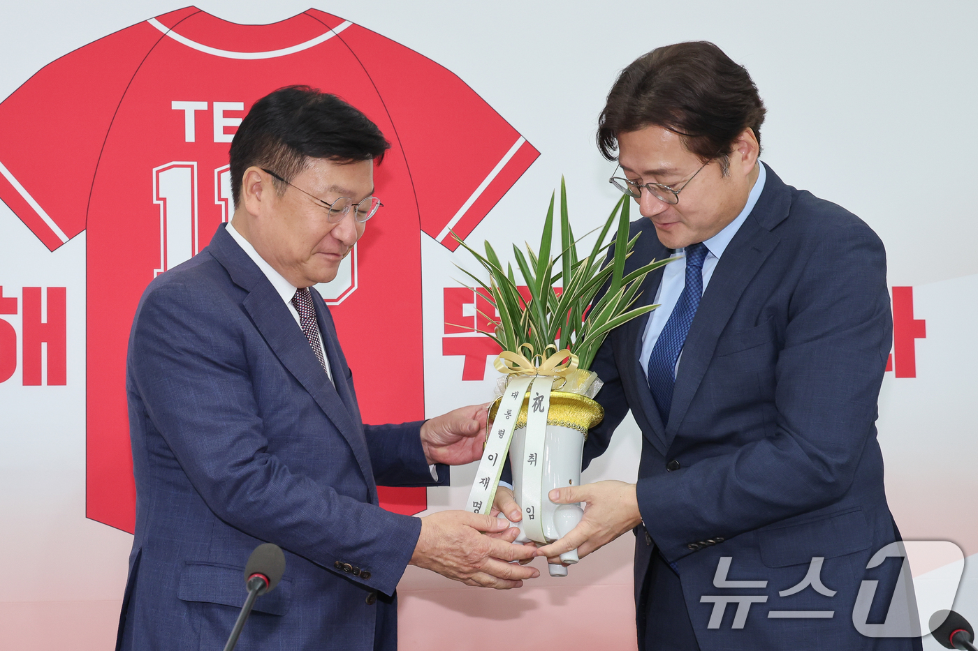 (서울=뉴스1) 안은나 기자 = 정점식 국민의힘 원내대표(왼쪽)가 11일 오후 서울 여의도 국회에서 홍익표 대통령비서실 정무수석으로부터 이재명 대통령 명의 축하 난을 받고 있다. …
