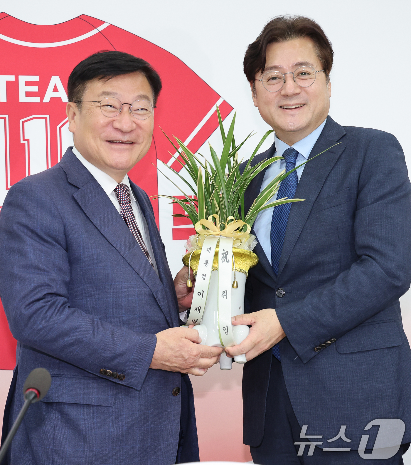 (서울=뉴스1) 안은나 기자 = 정점식 국민의힘 원내대표(왼쪽)가 11일 오후 서울 여의도 국회에서 홍익표 대통령비서실 정무수석으로부터 이재명 대통령 명의 축하 난을 받고 있다. …