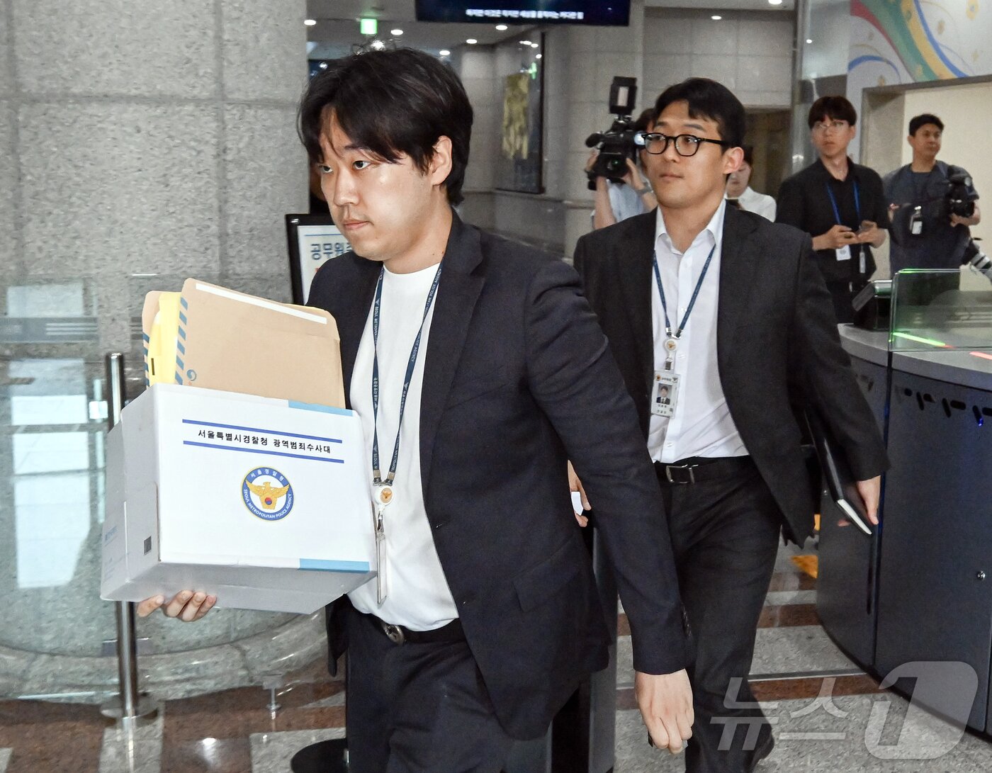 본문 이미지 - 6·3 지방선거 투표지 부족사태 사건을 수사 중인 서울경찰청 광역범죄수사대 관계자가 11일 경기도 과천시 중앙선거관리위원회 선거종합상황실에서 자료를 가지고 안내실로 이동하고 있다. (공동취재) 2026.6.11 ⓒ 뉴스1 김진환 기자