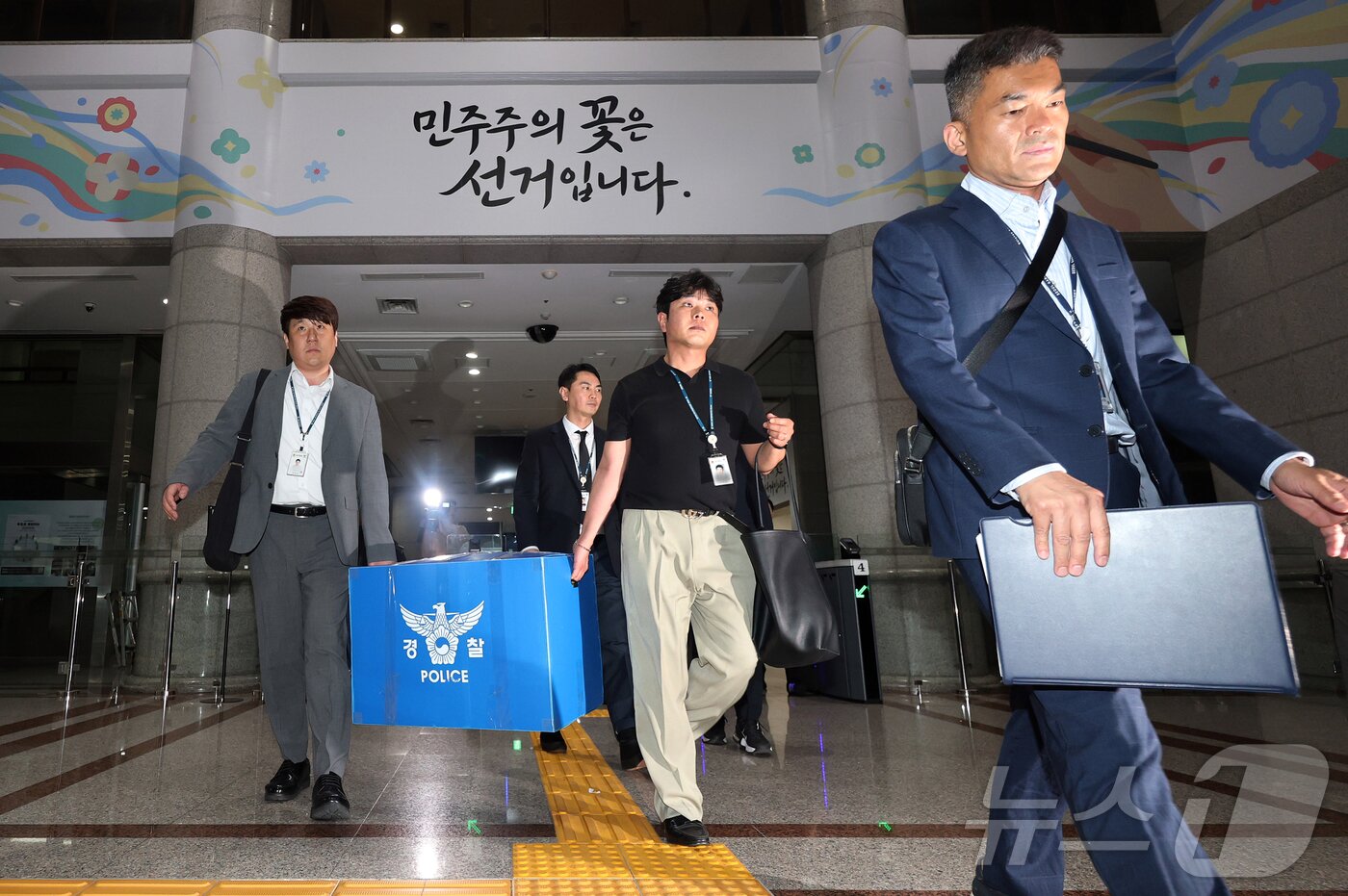 본문 이미지 - 6·3 지방선거 투표용지 부족 사태를 수사하는 검경 합동수사본부 수사관들이 11일 경기도 과천시 중앙선거관리위원회에 대한 압수수색을 마친 뒤 압수품을 들고 건물을 나오고 있다. (공동취재) 2026.6.11 ⓒ 뉴스1 김진환 기자