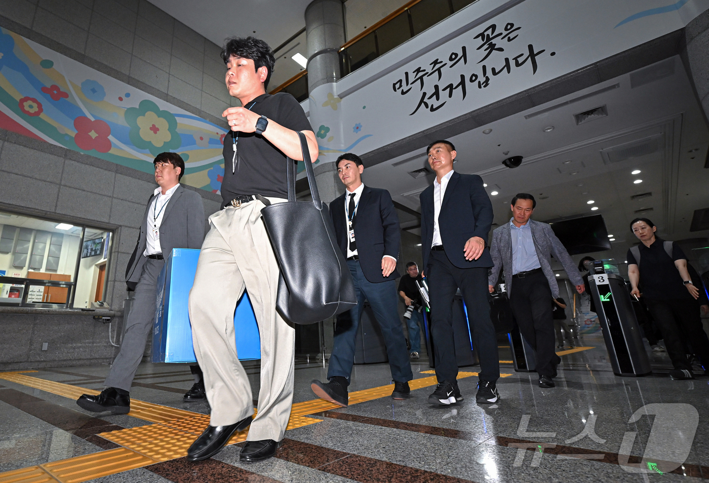 (과천=뉴스1) 이호윤 기자 = 6·3 지방선거 투표용지 부족 사태를 수사하는 검경 합동수사본부 수사관들이 11일 경기도 과천시 중앙선거관리위원회에 대한 압수수색을 마친 뒤 압수품 …
