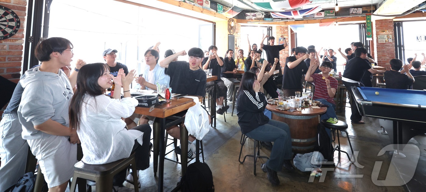 (전주=뉴스1) 유경석 기자 = 대한민국 축구 국가대표팀의 2026 국제축구연맹(FIFA) 북중미 월드컵 조별리그 첫 경기가 열린 12일 전북 전주시 한 상가에서 시민들이 경기를 …