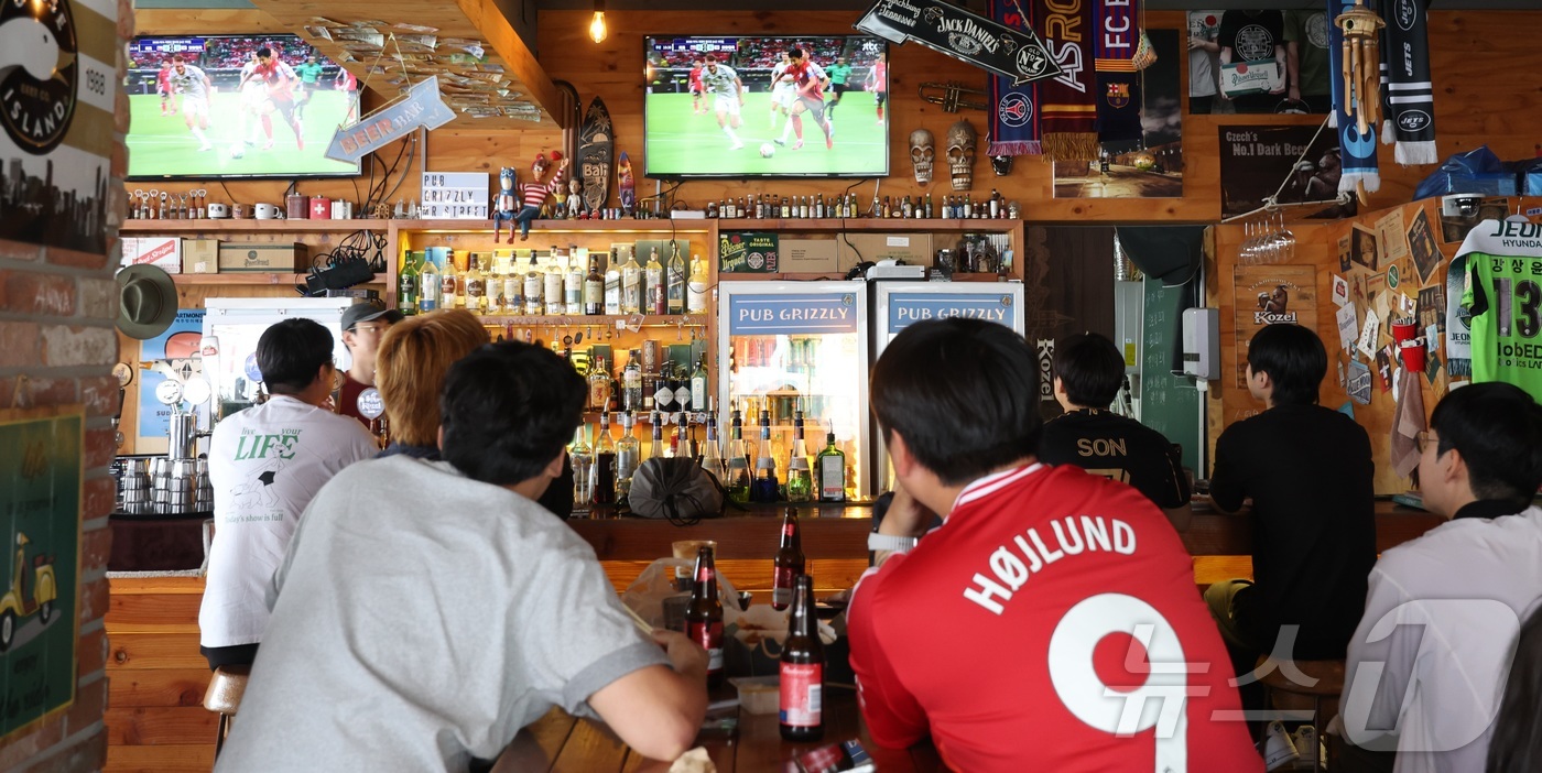 (전주=뉴스1) 유경석 기자 = 대한민국 축구 국가대표팀의 2026 국제축구연맹(FIFA) 북중미 월드컵 조별리그 첫 경기가 열린 12일 전북 전주시 한 상가에서 시민들이 경기를 …