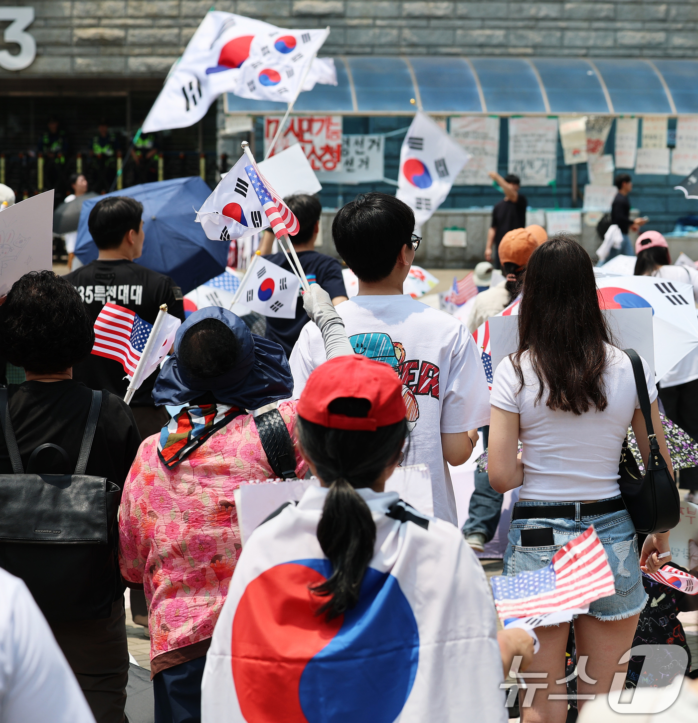 (서울=뉴스1) 오대일 기자 = 제9회 전국동시지방선거 투표용지 부족 사태를 규탄하는 개표소 봉쇄 시위가 계속된 12일 서울 송파구 올림픽공원 핸드볼경기장 앞에서 시민들이 태극기를 …