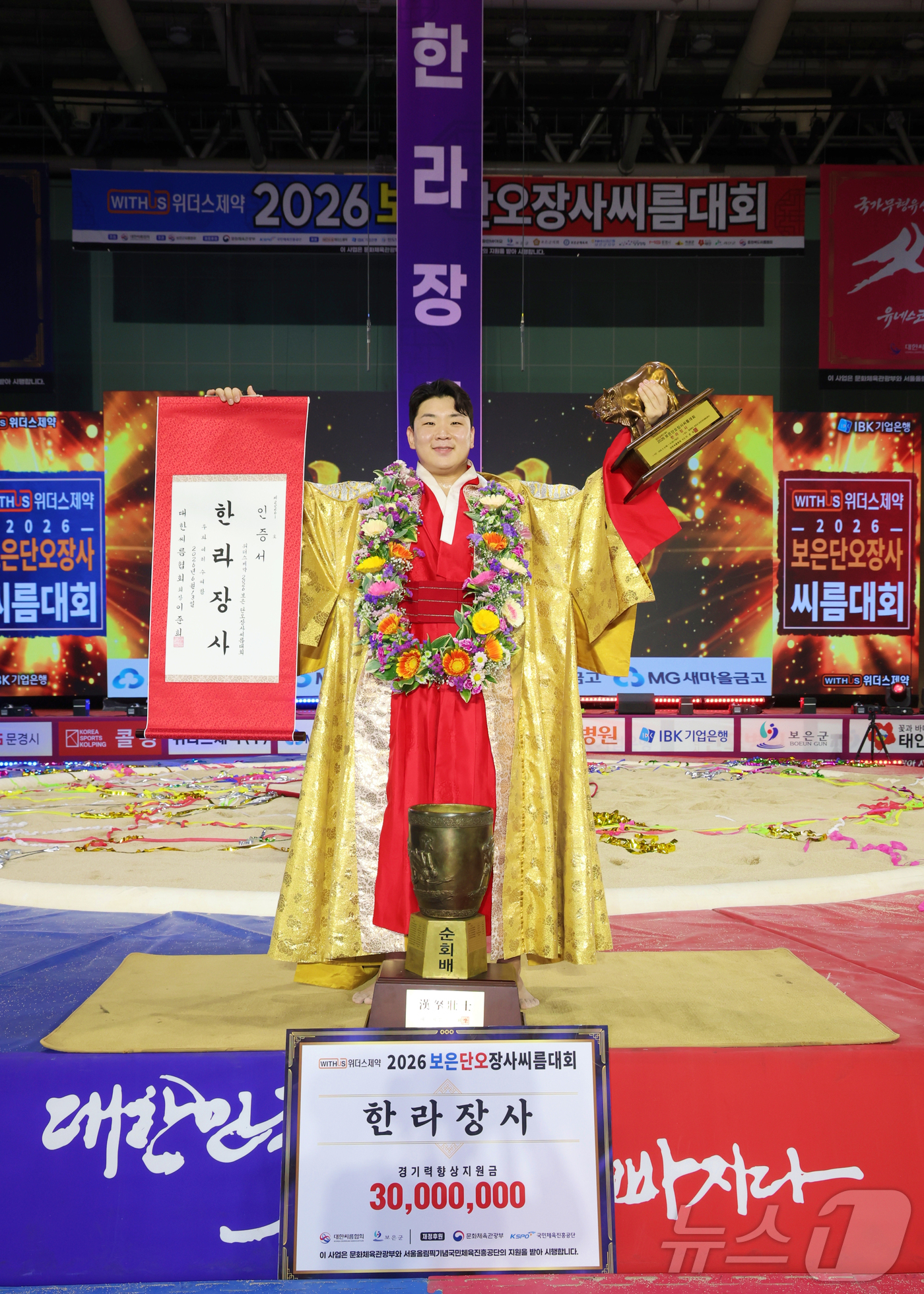 (서울=뉴스1) = 13일 충북 보은군 보은국민체육센터에서 열린 ‘위더스제약 2026 보은단오장사씨름대회’ 한라장사(105kg이하)에 오른 김무호(울주군청)가 장사인증서와 황소트로 …