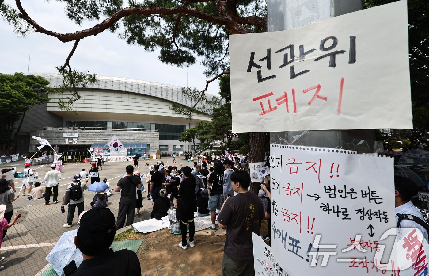 본문 이미지 - 6·3 지방선거 투표용지 부족 사태에 반발한 시민들이 14일 서울 송파구 올림픽공원 핸드볼경기장 개표소 앞에 모여 재선거를 요구하는 구호를 외치고 있다. 2026.6.14 ⓒ 뉴스1 김도우 기자