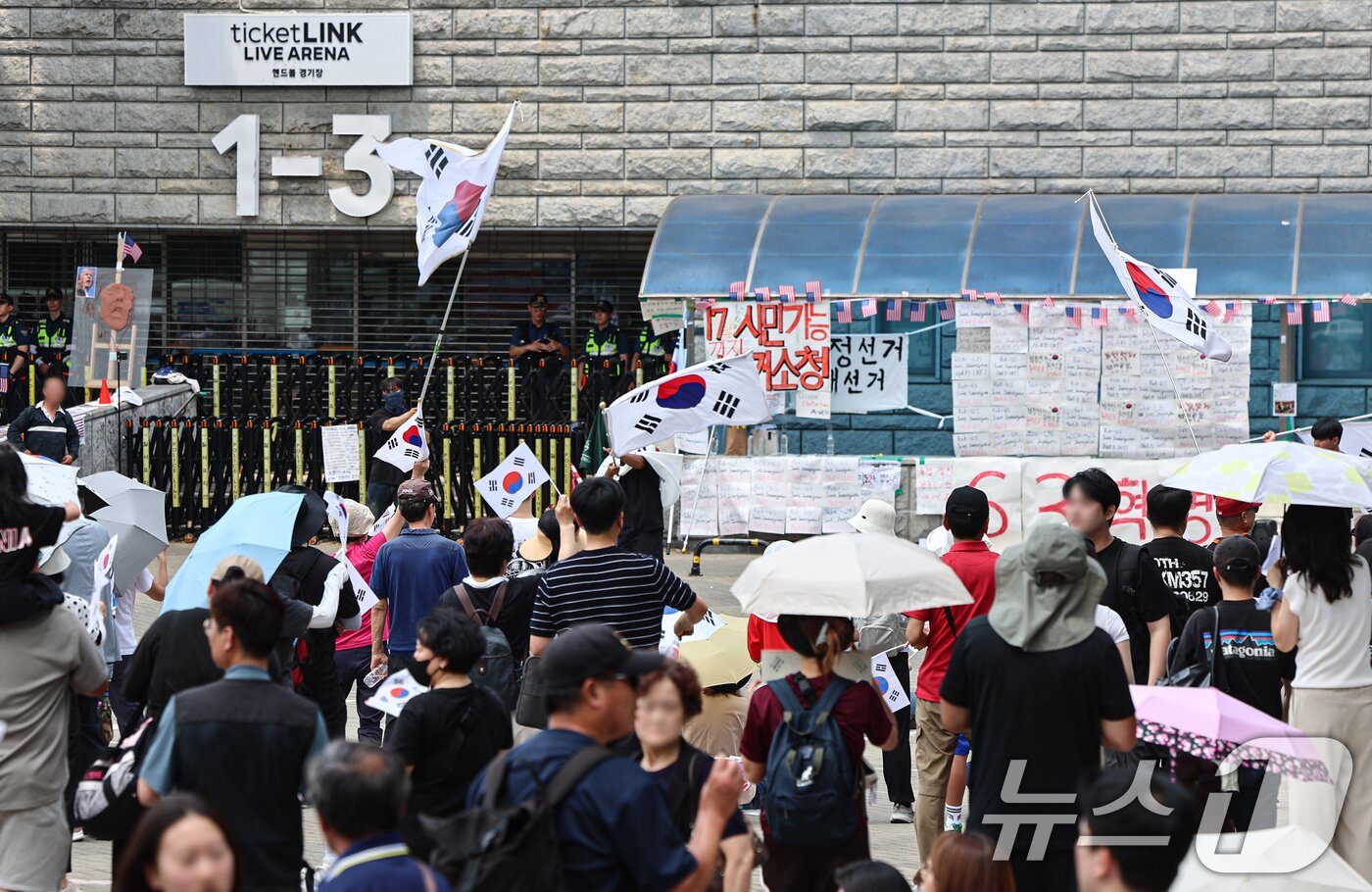 본문 이미지 - 6·3 지방선거 투표용지 부족 사태에 반발한 시민들이 14일 서울 송파구 올림픽공원 핸드볼경기장 개표소 앞에 모여 재선거를 요구하는 구호를 외치고 있다. 2026.6.14 ⓒ 뉴스1 김도우 기자
