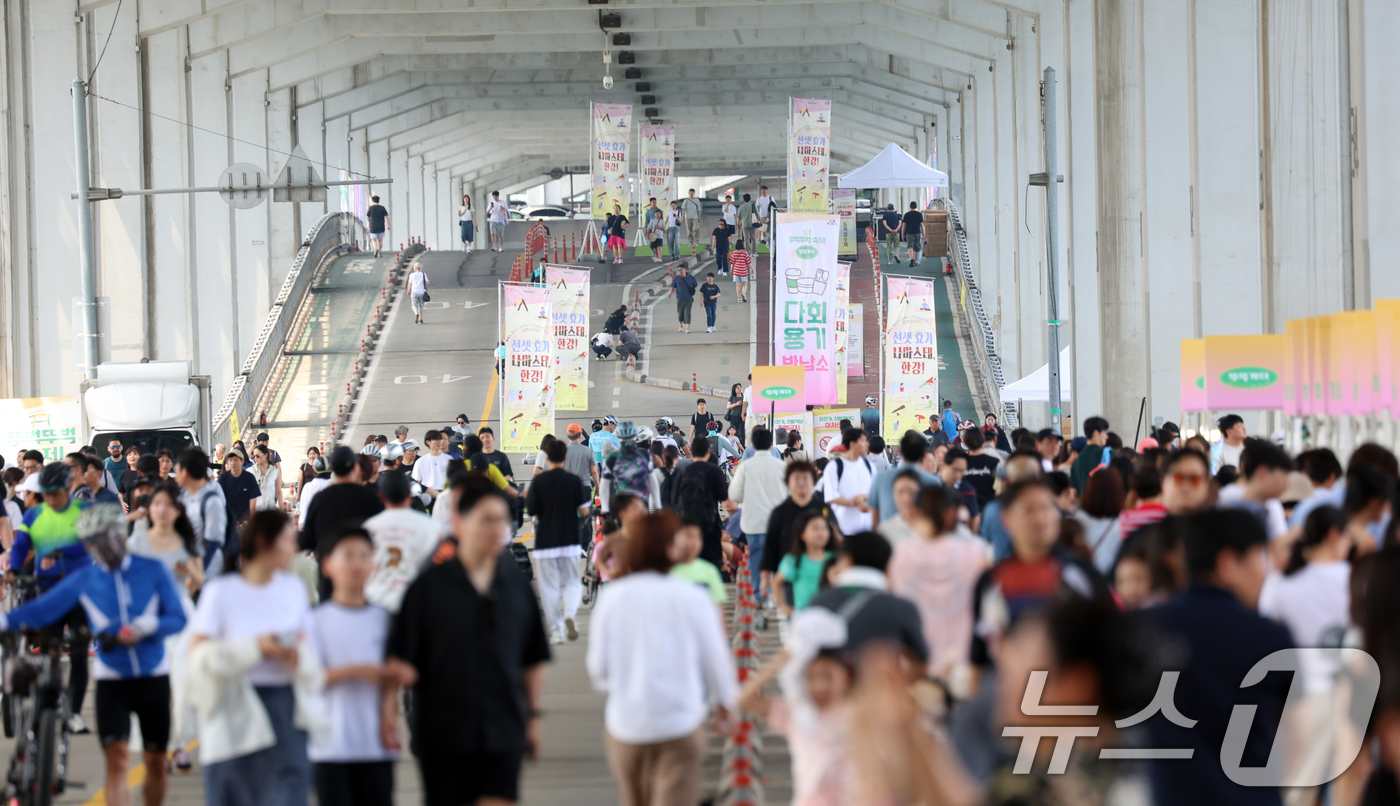 (서울=뉴스1) 김명섭 기자 = 14일 오후 서울 잠수교에서 열린 '2026차없는 잠수교 뚜벅뚜벅 축제'에서 시민들이 뜨거운 태양을 피해 축제를 즐기고 있다. 이날 낮 기온은 서울 …