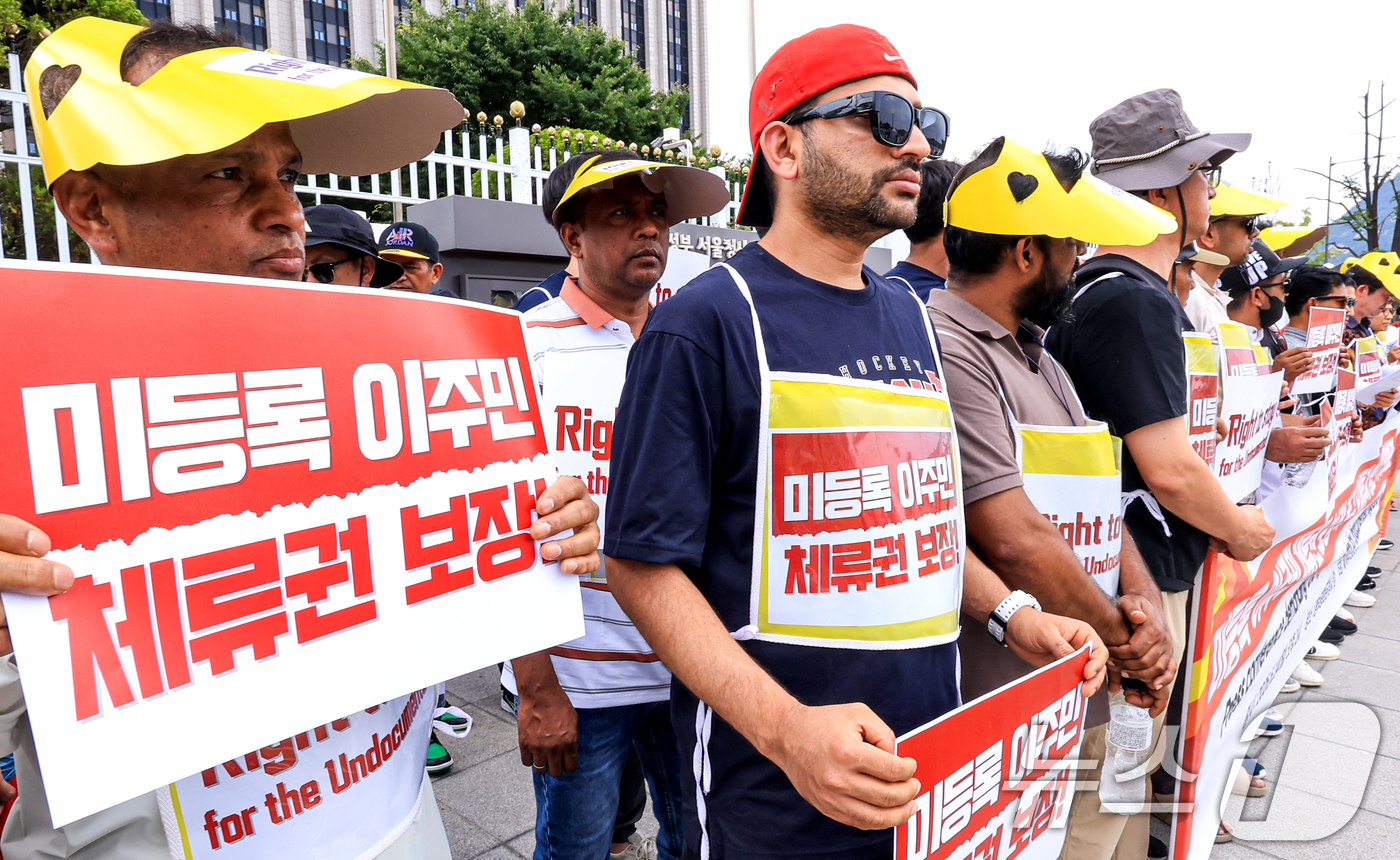 (서울=뉴스1) 이호윤 기자 = 14일 서울 정부서울청사 앞에서 열린 미등록 이주민 체류권 보장 촉구 오체투지 행진 기자회견에서 참가자들이 피켓을 들고 있다. 2026.6.14/뉴 …