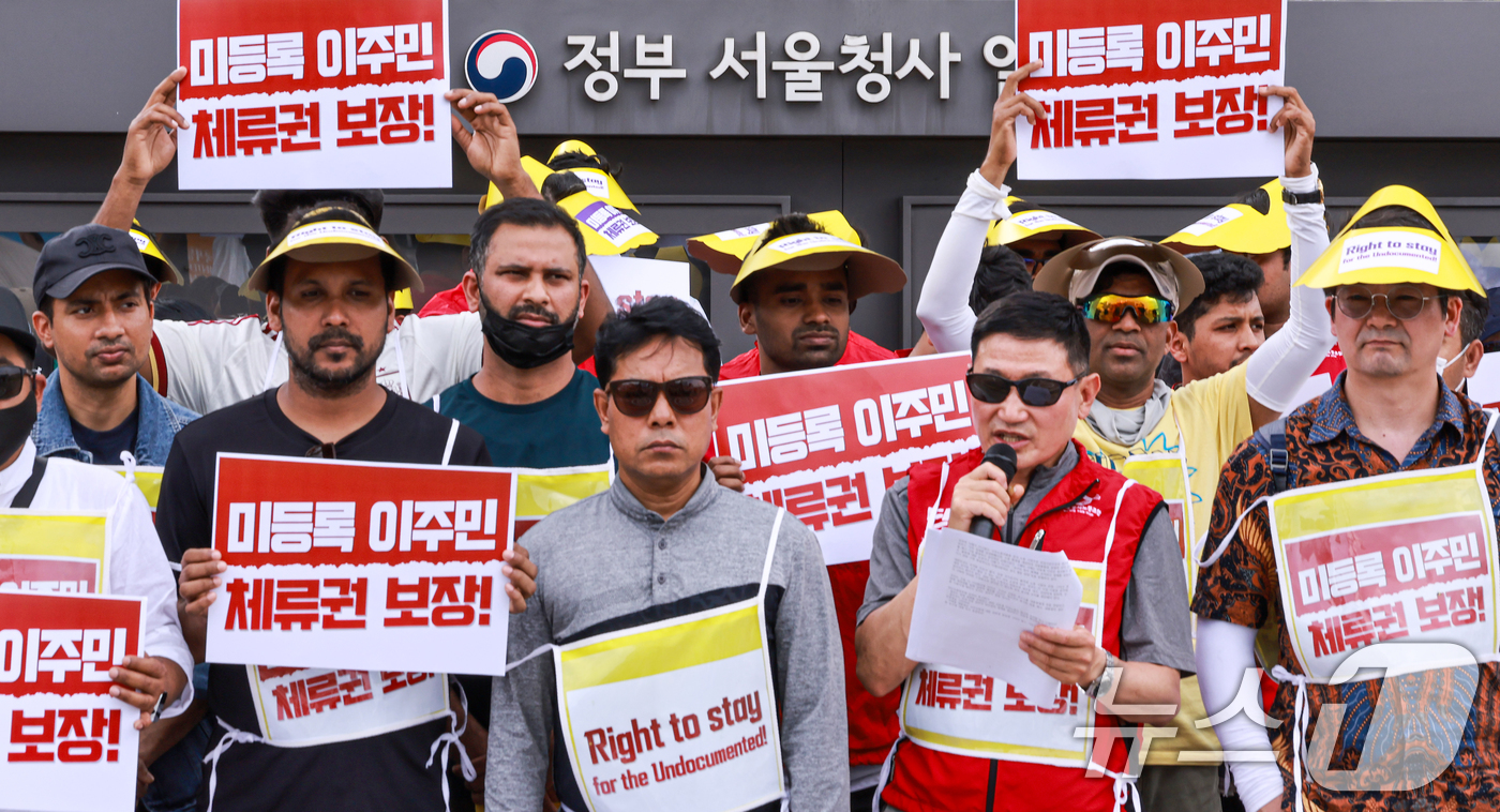 (서울=뉴스1) 이호윤 기자 = 14일 서울 정부서울청사 앞에서 열린 미등록 이주민 체류권 보장 촉구 오체투지 행진 기자회견에서 참가자들이 피켓을 들고 있다. 2026.6.14/뉴 …