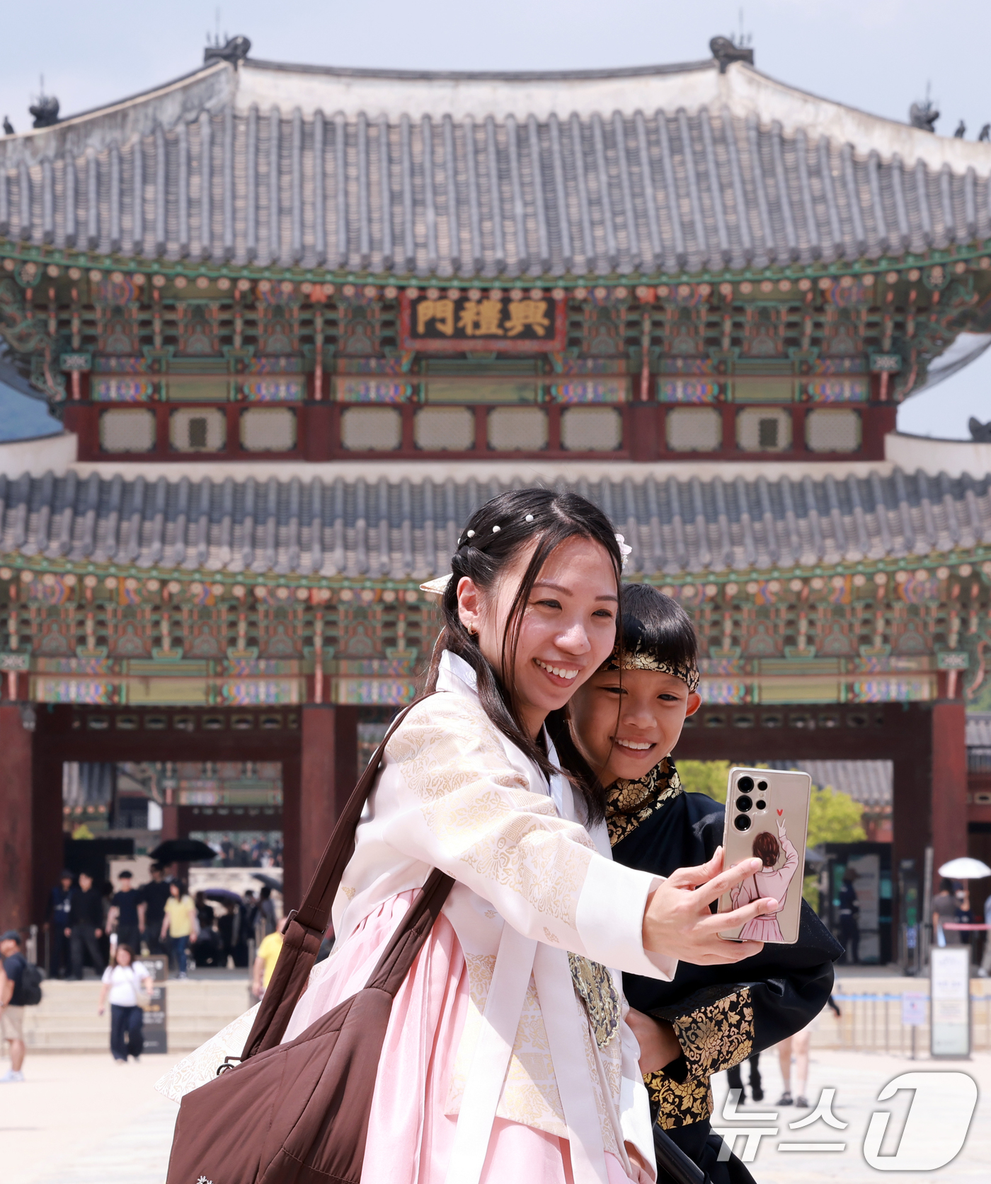 (서울=뉴스1) 이호윤 기자 = 14일 서울 종로구 경복궁에서 한복을 입은 외국인 모자가 셀카를 찍고 있다.이날 한국문화관광연구원의 '국제관광시장 전망'에 따르면 원화 가치가 하락 …