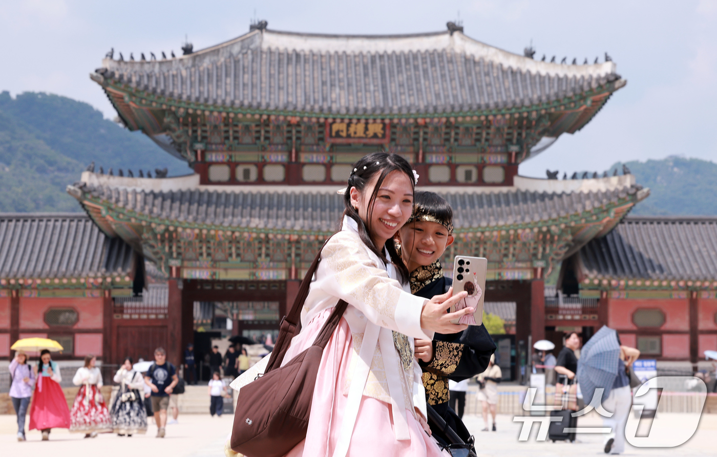 (서울=뉴스1) 이호윤 기자 = 14일 서울 종로구 경복궁에서 한복을 입은 외국인 모자가 셀카를 찍고 있다.이날 한국문화관광연구원의 '국제관광시장 전망'에 따르면 원화 가치가 하락 …