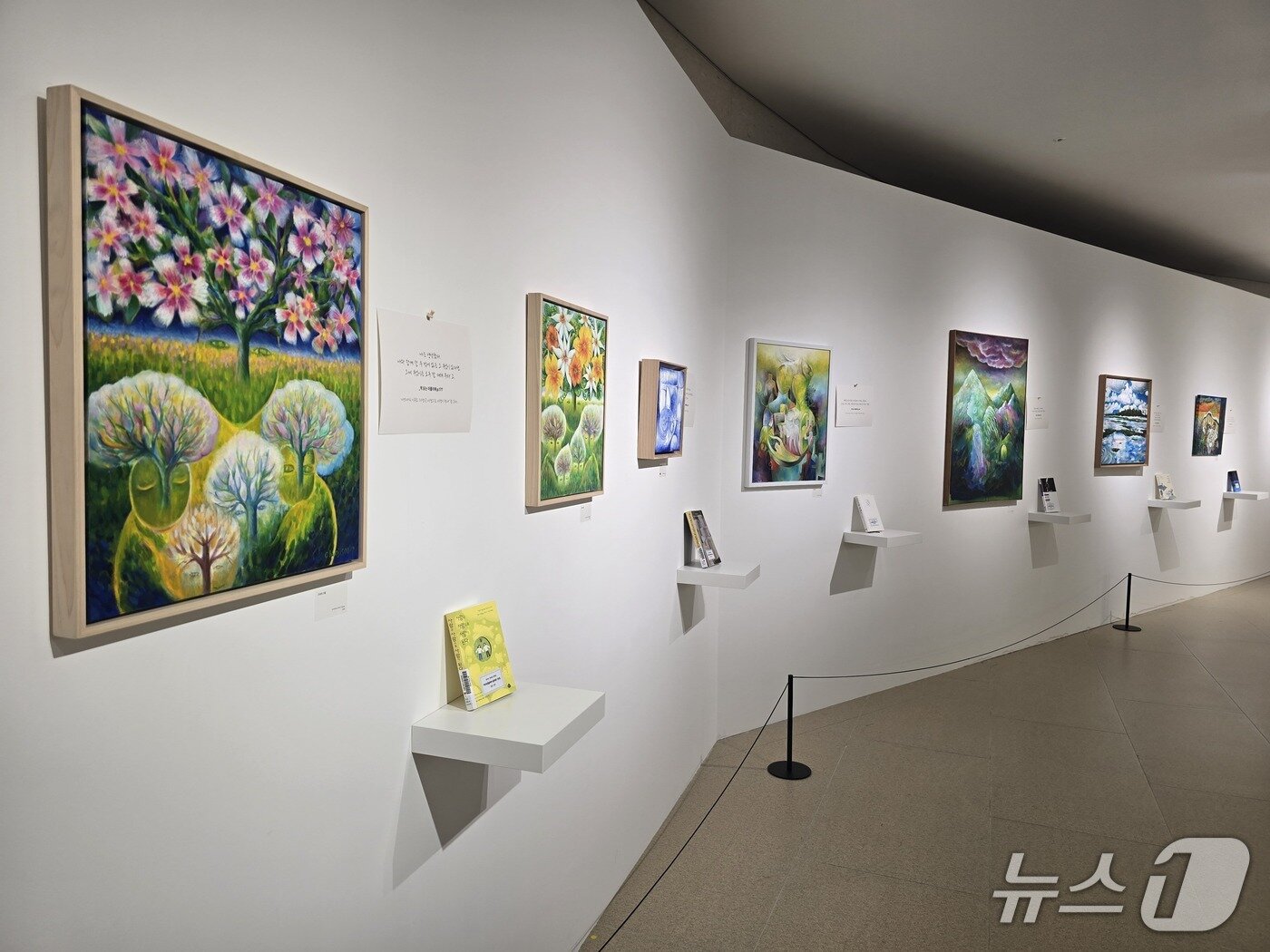 본문 이미지 - 14일 수원 경기도서관에서 개최된 천지수 작가 '독후화' 북토크에서 천지수 작가의 작품이 책과 함께 전시되고 있다. ⓒ 뉴스1 김정한 기자
