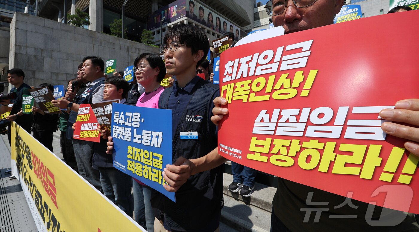본문 이미지 - 한국노총과 민주노총 관계자들이 15일 서울 종로구 세종문화회관 앞 계단에서 2027년 적용 최저임금 노동계 요구안 발표 기자회견을 하고 있다. 2026.6.15 ⓒ 뉴스1 김성진 기자
