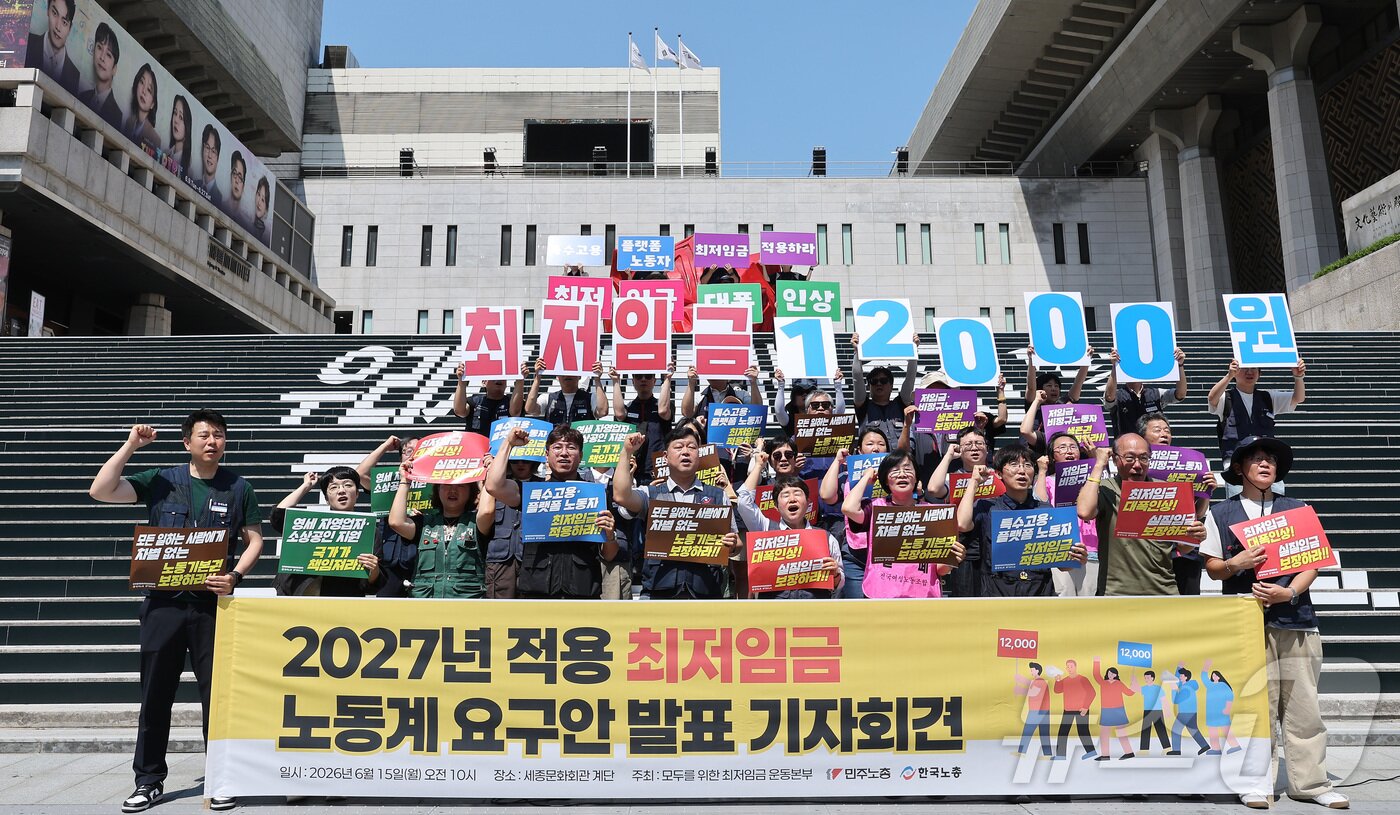 본문 이미지 - 한국노총과 민주노총 관계자들이 15일 서울 종로구 세종문화회관 앞 계단에서 열린 2027년 적용 최저임금 노동계 요구안 발표 기자회견에서 구호를 외치고 있다. 2026.6.15 ⓒ 뉴스1 김성진 기자