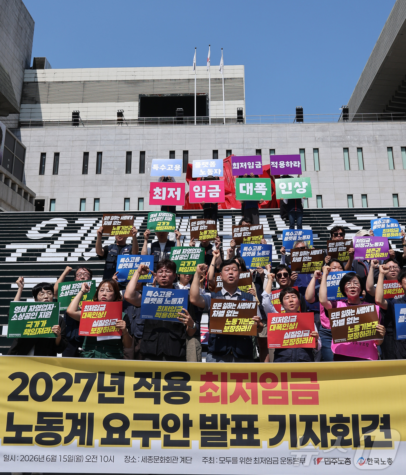 (서울=뉴스1) 김성진 기자 = 한국노총과 민주노총 관계자들이 15일 서울 종로구 세종문화회관 앞 계단에서 열린 2027년 적용 최저임금 노동계 요구안 발표 기자회견에서 구호를 외 …
