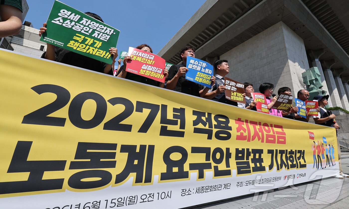 본문 이미지 - 한국노총과 민주노총 관계자들이 15일 서울 종로구 세종문화회관 앞 계단에서 2027년 적용 최저임금 노동계 요구안 발표 기자회견을 하고 있다. 2026.6.15 ⓒ 뉴스1 김성진 기자