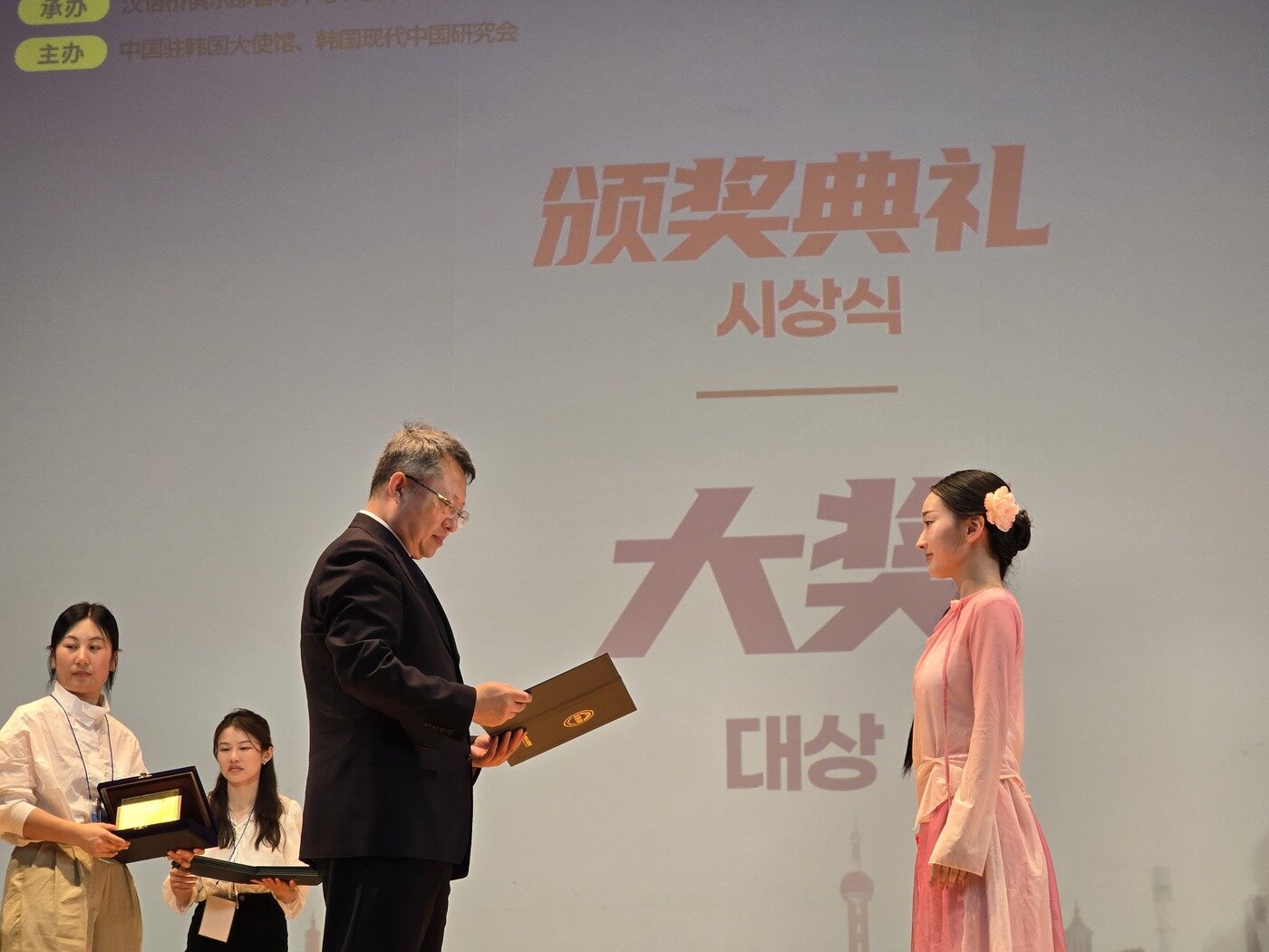 본문 이미지 - 13일, 제25회 '한어교' 세계중국어대회 한국지역 결선전에서 대상을 수상한 국민대학교 이서연 학생이 시상식에서 주한중국대사관 마이구이성 공사로부터 상장을 수여받고 있다. (이창호 한중교류촉진위원회 위원장 제공)