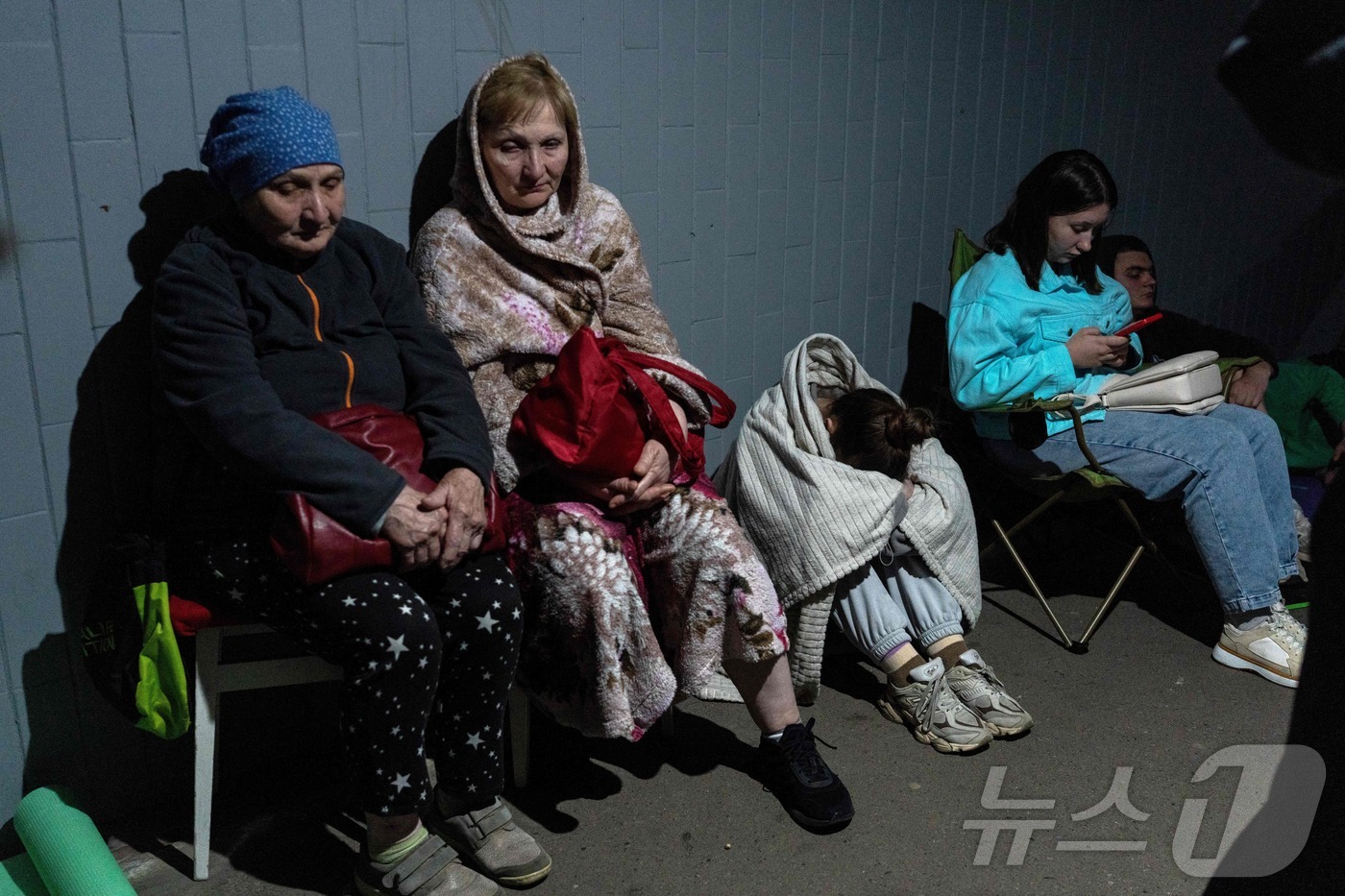 (키이우 AFP=뉴스1) 안소연 수습기자 = 15일(현지시간) 러시아의 미사일 공격으로 파손된 키이우의 한 주거용 건물 밖에 주민들이 모여 있다. 러시아는 우크라이나 주요 도시들을 …