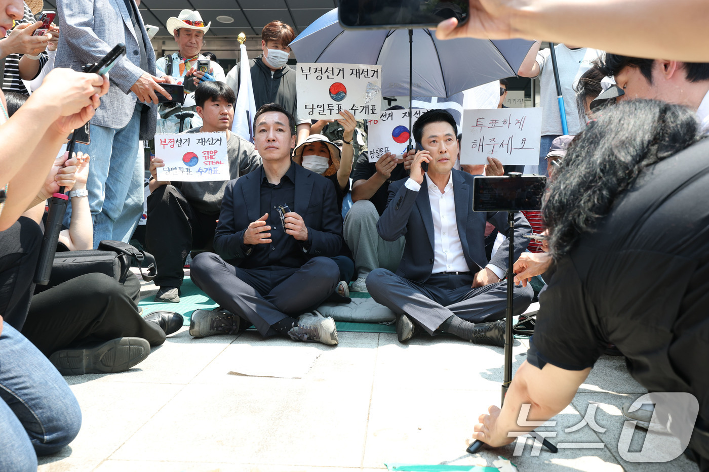 (서울=뉴스1) 김도우 기자 = 장동혁 국민의힘 대표가 16일 서울 송파구 올림픽공원 핸드볼경기장(잠실 개표소)을 찾아 시위대와 함께 앉아 있다. (공동취재)2026.6.16/뉴스 …