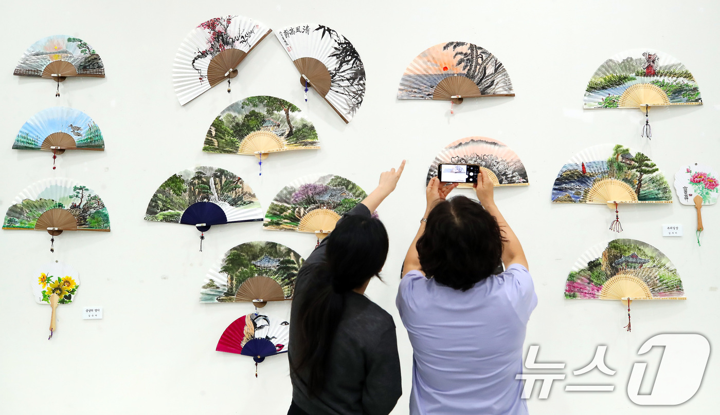 (대구=뉴스1) 공정식 기자 = 16일 대구 달성군 달성문화원에서 열린 단오절 맞이 '하풍전(夏風展)' 부채 전시회를 찾은 시민들이 다양한 부채를 감상하고 있다.달성문화원 한국화반 …