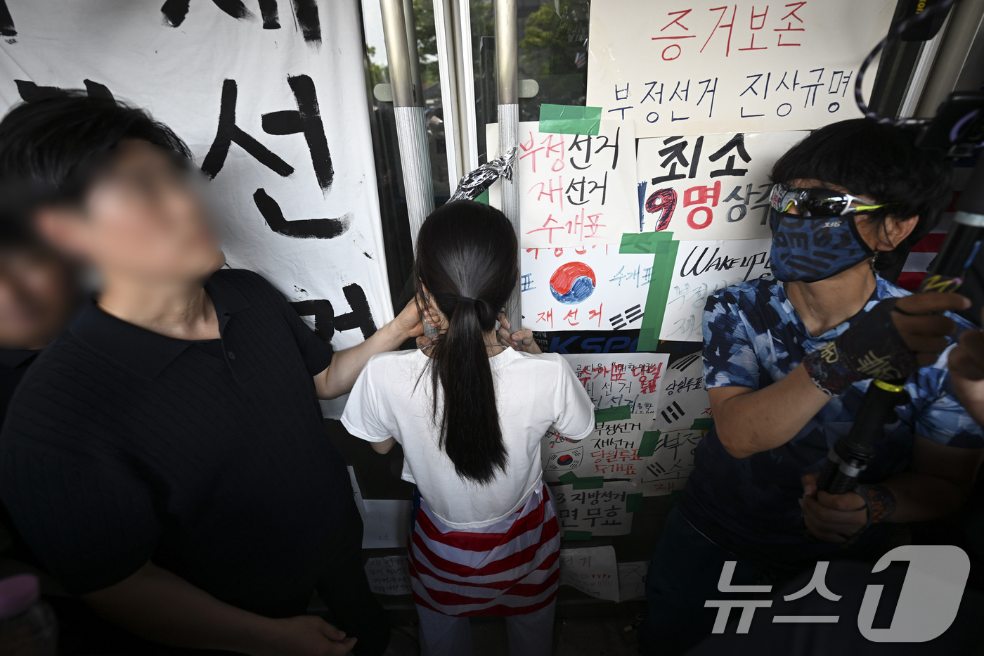 (서울=뉴스1) 김도우 기자 = 16일 서울 올림픽공원 핸드볼경기장에서 한 시위 참가자가 대한체육회 등 입주 단체 관계자들의 진입을 막아서고 있다. (공동취재) 2026.6.16/ …