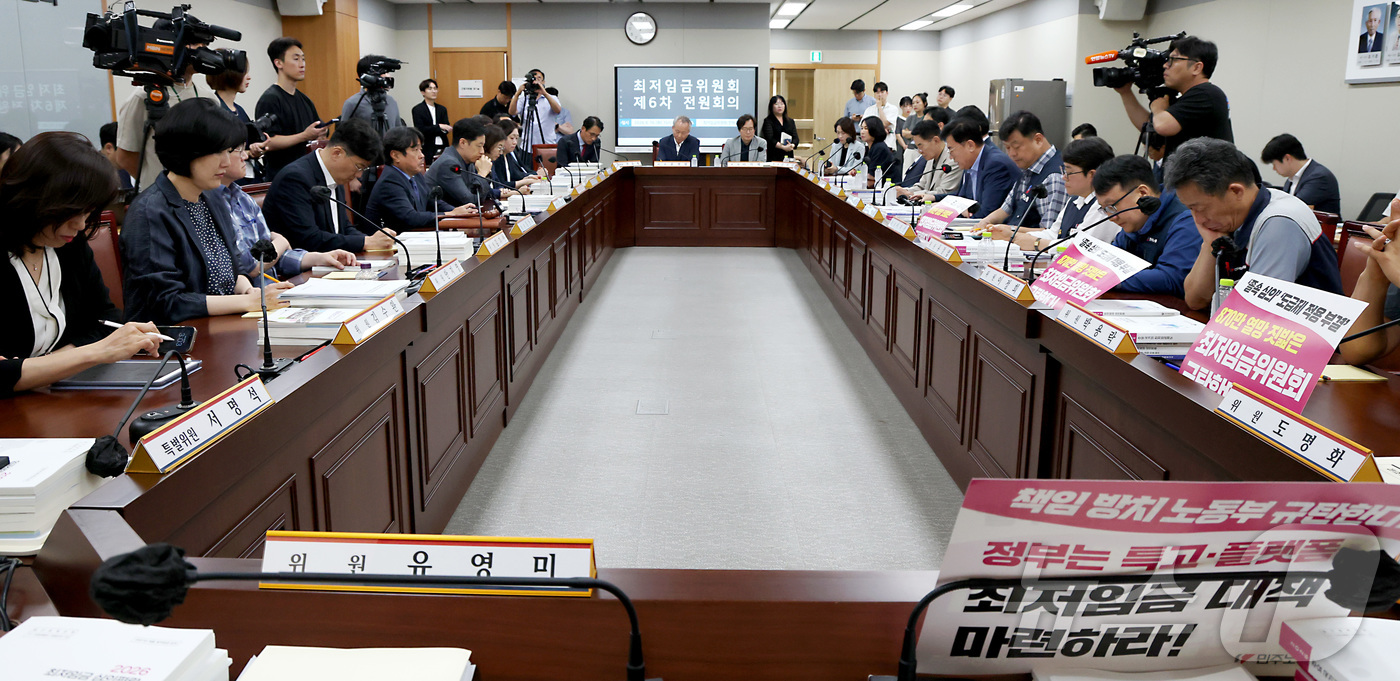 (세종=뉴스1) 김기남 기자 = 16일 세종시 정부세종청사 최저임금위원회에서 열린 2027년도 최저임금위원회 6차 전원회의에 참석한 근로자위원들이 손팻말을 게시하고 회의내용을 듣고 …