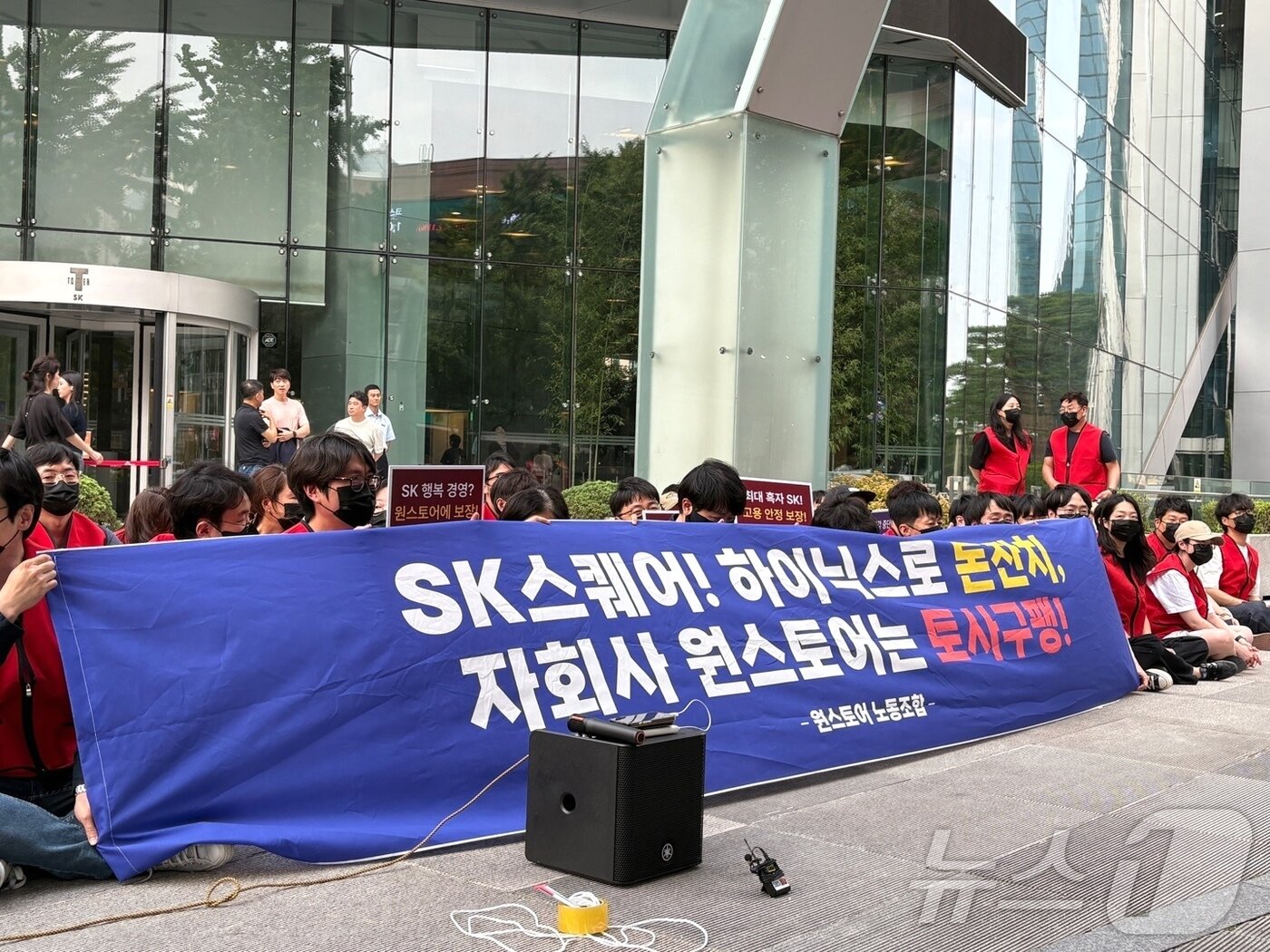 본문 이미지 - 원스토어 노동조합 조합원들이 16일 오후 서울 중구 SK스퀘어 본사 앞에서 열린 매각 반대 집회에서 손피켓을 들고 있다. 2026.6.16 ⓒ 뉴스1 김민재 기자