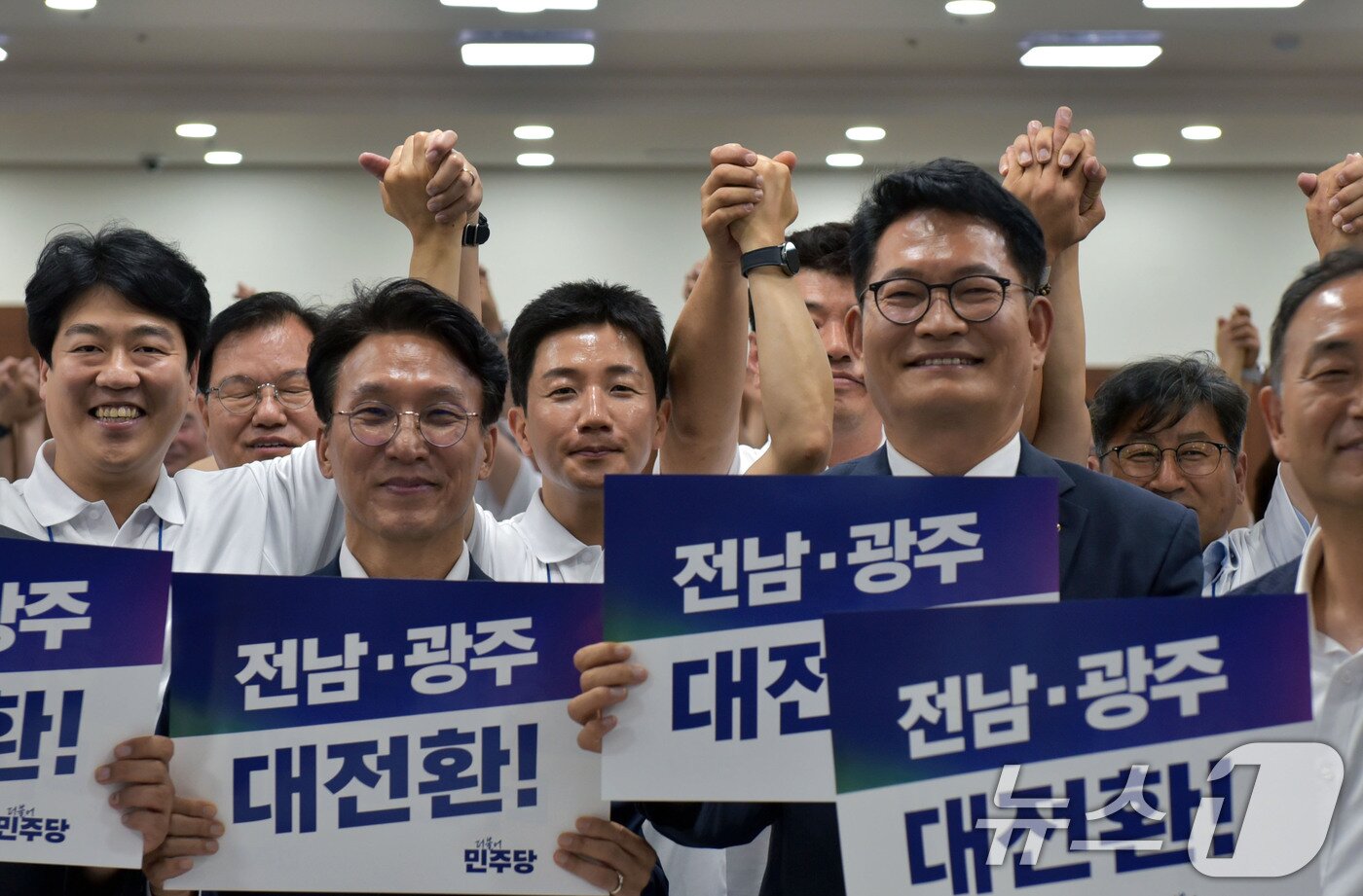 본문 이미지 - 김민석 국무총리와 송영길 더불어민주당 의원이 16일 전남 보성 다비치콘도에서 열린 제9회 전국동시지방선거 전남광주통합특별시의원 당선인 워크숍에서 손피켓을 들고 기념촬영을 하고 있다. 2026.6.16 ⓒ 뉴스1 김성준 기자