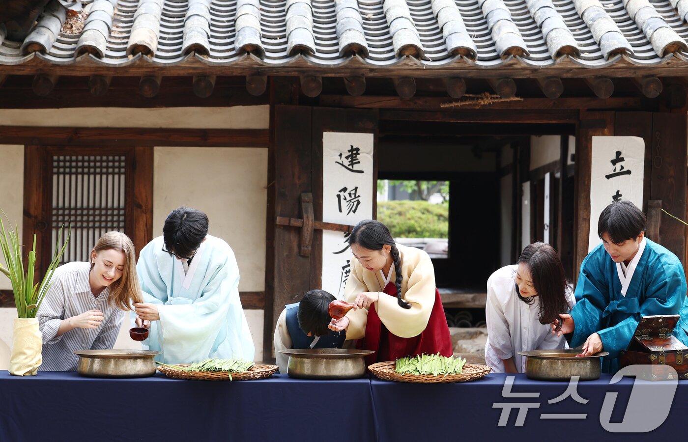 본문 이미지 - 17일 오전 서울 종로구 국립민속박물관 오촉댁 앞마당에서 열린 '수리 술의 수릿날, 단오' 행사에서 외국인과 어린이가 창포물에 머리 감기 체험을 하고 있다. 2026.6.17 ⓒ 뉴스1 김민지 기자