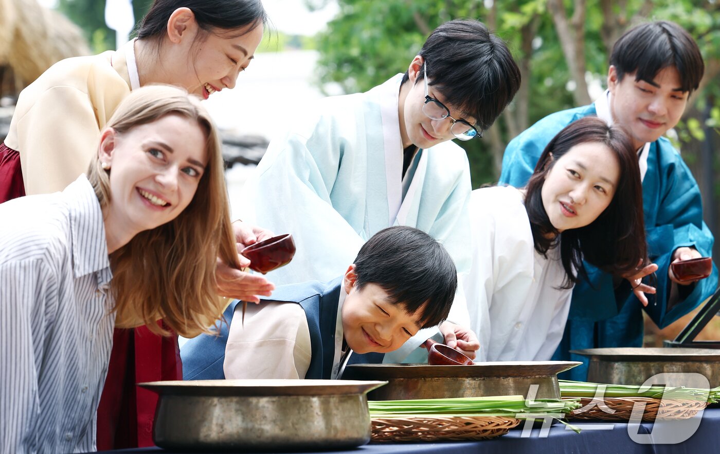 본문 이미지 - 17일 오전 서울 종로구 국립민속박물관 오촉댁 앞마당에서 열린 '수리 술의 수릿날, 단오' 행사에서 외국인과 어린이가 창포물에 머리 감기 체험을 하고 있다. 2026.6.17 ⓒ 뉴스1 김민지 기자