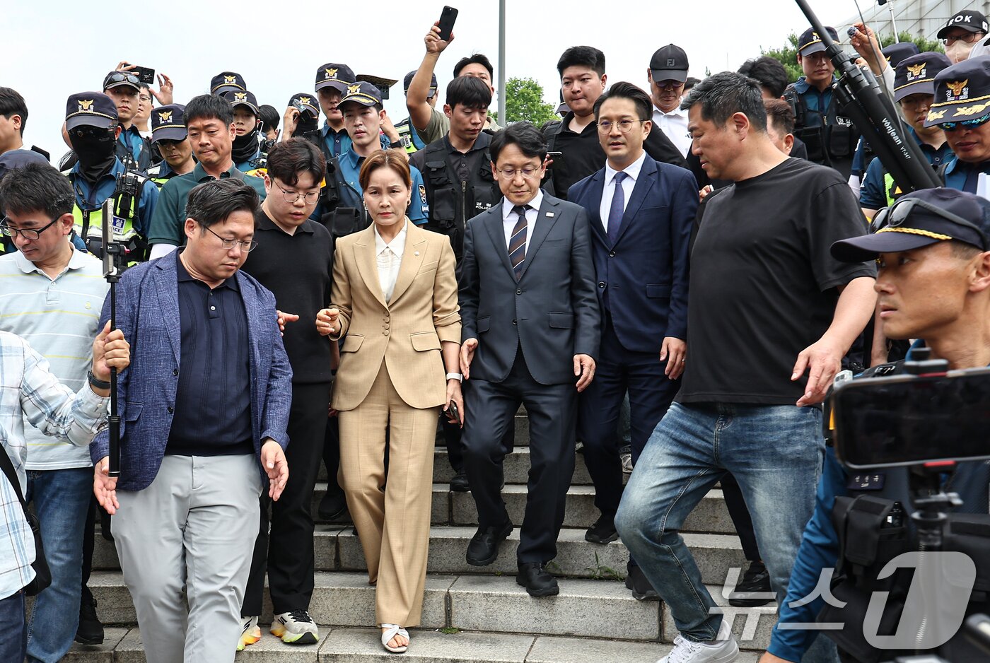 본문 이미지 - 임오경, 전용기, 천준호 더불어민주당 의원이 17일 서울 송파구 올림픽공원 핸드볼경기장 앞에서 투표용지 부족 사태를 규탄하는 시민들에게 항의를 받으며 이동하고 있다. 2026.6.17 ⓒ 뉴스1 김도우 기자
