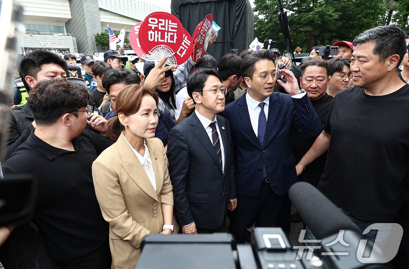 본문 이미지 - 임오경, 전용기, 천준호 더불어민주당 의원이 17일 서울 송파구 올림픽공원 핸드볼경기장 앞에서 투표용지 부족 사태를 규탄하는 시민들에게 항의를 받으며 이동하고 있다. 2026.6.17 ⓒ 뉴스1 김도우 기자