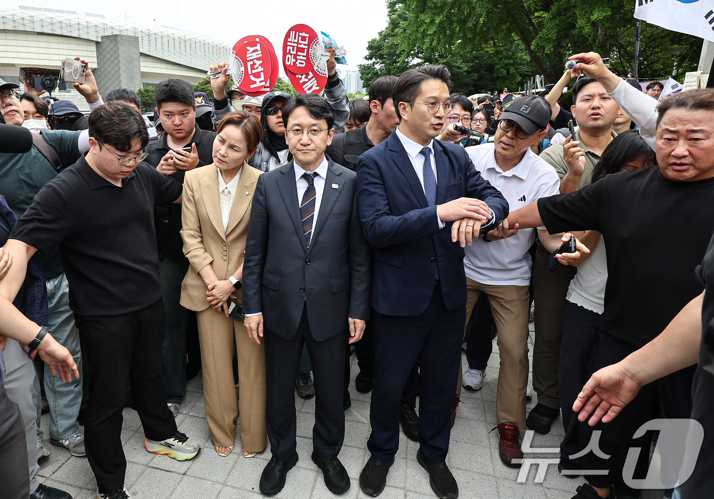 (서울=뉴스1) 김도우 기자 = 임오경, 전용기, 천준호 더불어민주당 의원이 17일 서울 송파구 올림픽공원 핸드볼경기장 앞에서 투표용지 부족 사태를 규탄하는 시민들에게 항의를 받으 …