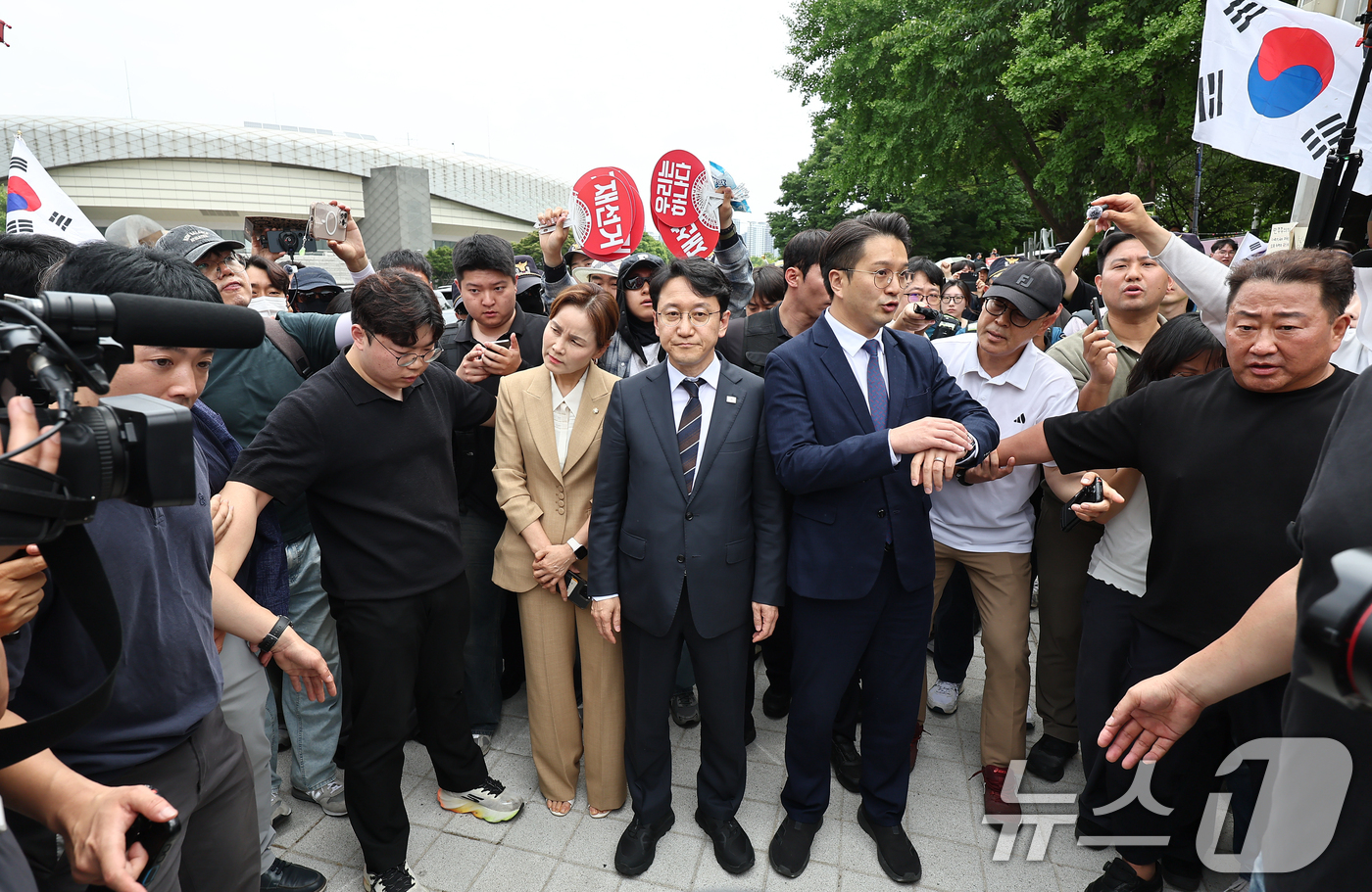 (서울=뉴스1) 김도우 기자 = 임오경, 전용기, 천준호 더불어민주당 의원이 17일 서울 송파구 올림픽공원 핸드볼경기장 앞에서 투표용지 부족 사태를 규탄하는 시민들에게 항의를 받으 …