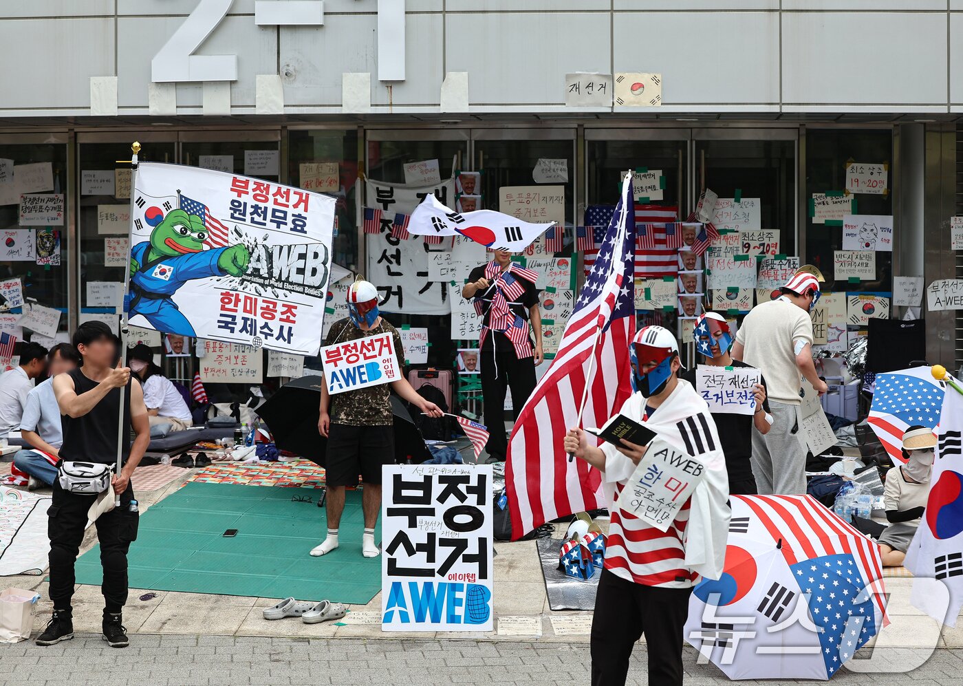 본문 이미지 - 제9회 전국동시지방선거 투표용지 부족 사태를 규탄하는 개표소 봉쇄 시위가 계속된 17일 서울 송파구 올림픽공원 핸드볼경기장 앞에서 시민들이 재선거 등을 요구하고 있다. 2026.6.17 ⓒ 뉴스1 김도우 기자