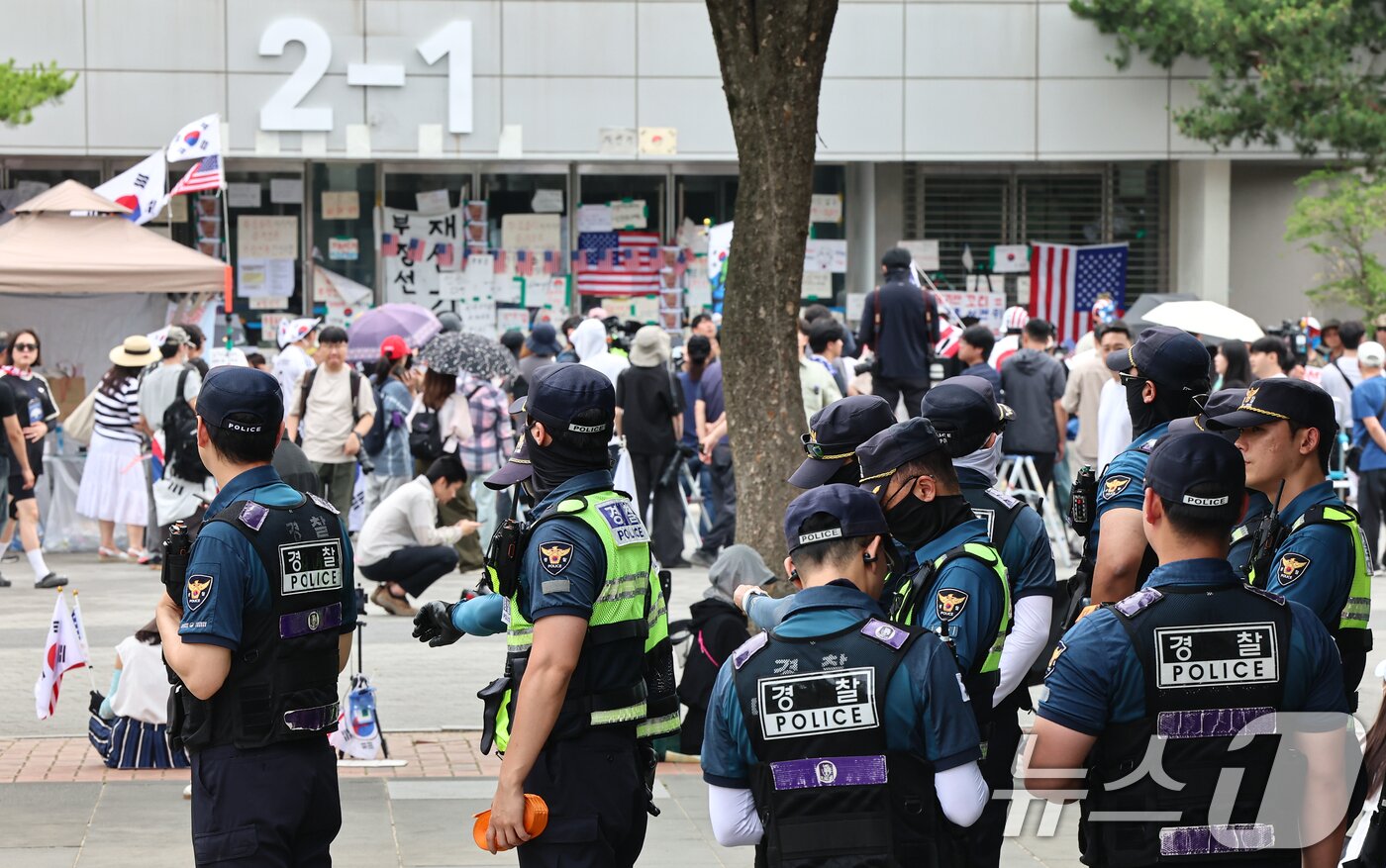 본문 이미지 - 제9회 전국동시지방선거 투표용지 부족 사태를 규탄하는 개표소 봉쇄 시위가 계속된 17일 서울 송파구 올림픽공원 핸드볼경기장 앞에서 경찰들이 대기하고 있다. 2026.6.17 ⓒ 뉴스1 김도우 기자