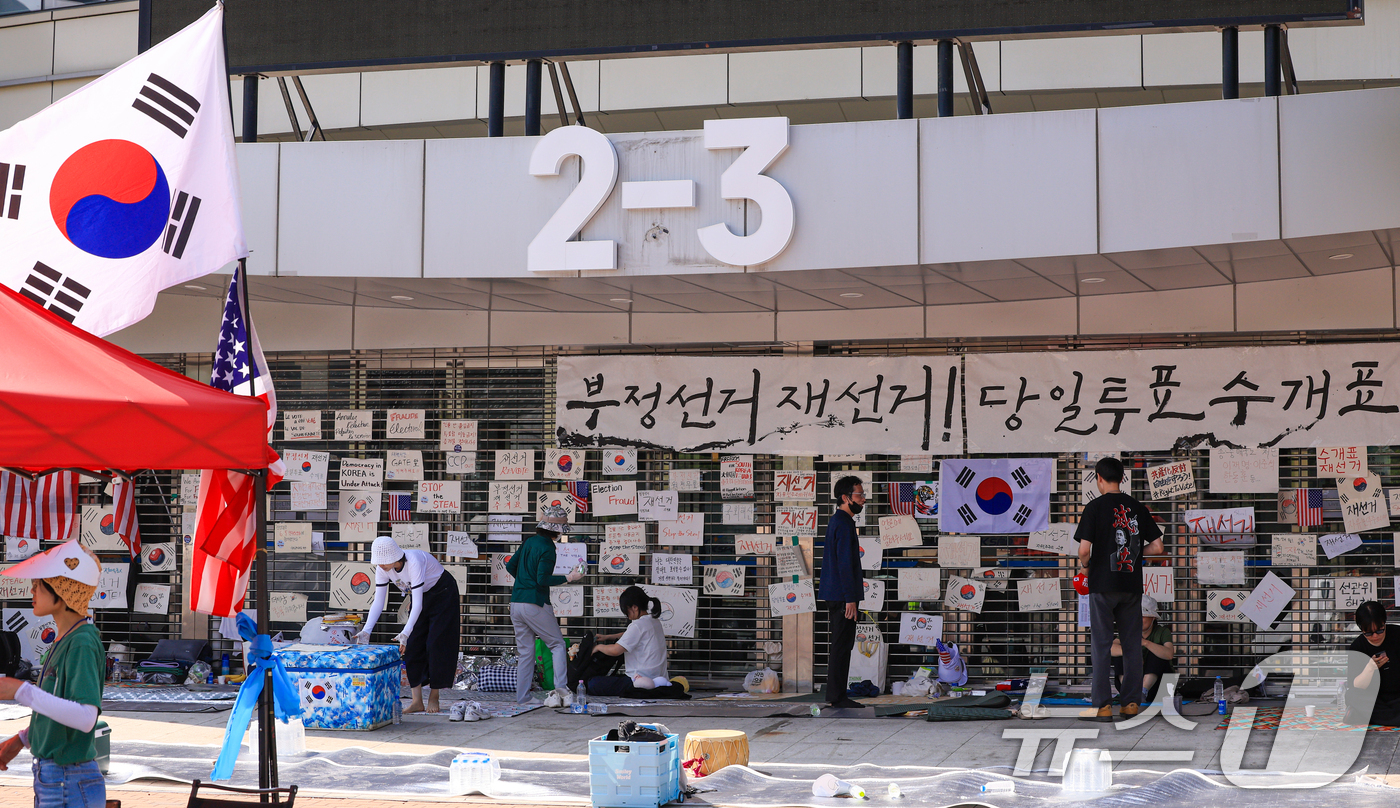 (서울=뉴스1) 이호윤 기자 = 제9회 전국동시지방선거 투표용지 부족 사태를 규탄하는 개표소 봉쇄 시위가 계속된 18일 서울 송파구 올림픽공원 핸드볼경기장에서 시민들이 재선거 등을 …
