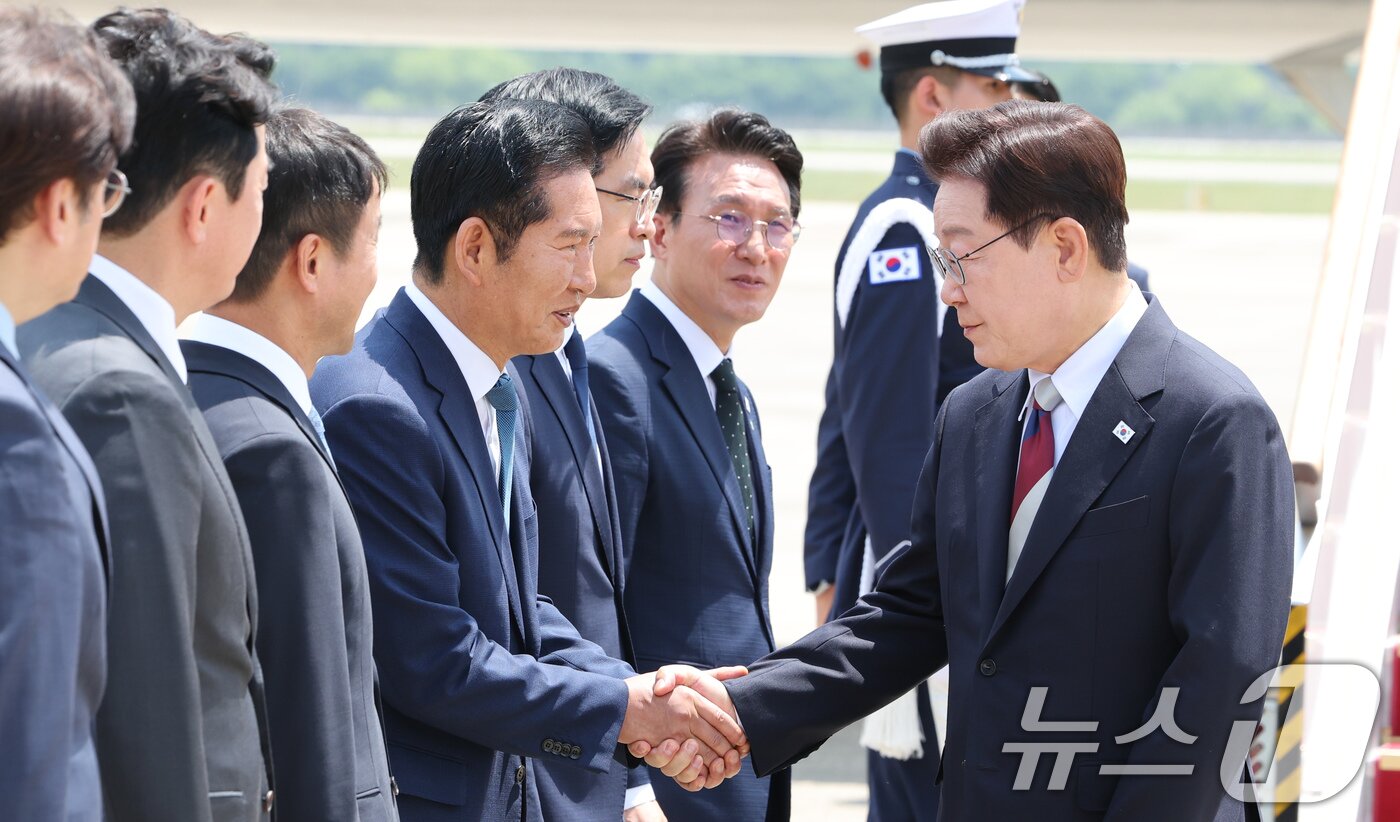 본문 이미지 - 주요 7개국(G7) 정상회의 일정을 마친 이재명 대통령이 18일 경기 성남 서울공항에 도착해 정청래 더불어민주당 대표와 인사를 나누고 있다. 2026.6.18 ⓒ 뉴스1 허경 기자