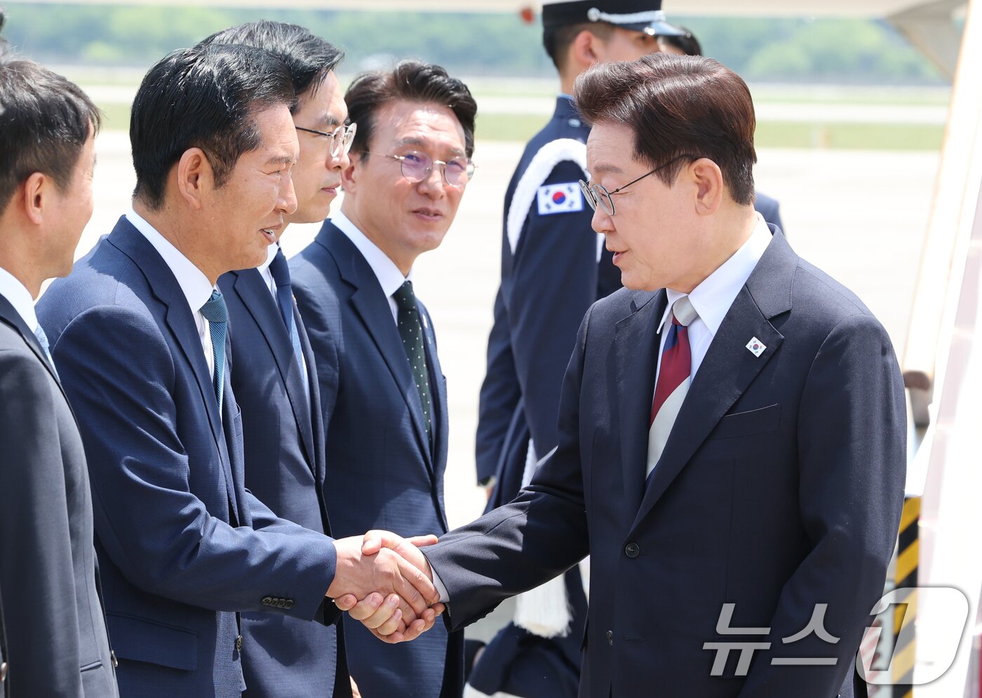 본문 이미지 - 주요 7개국(G7) 정상회의 일정을 마친 이재명 대통령이 18일 경기 성남 서울공항에 도착해 정청래 더불어민주당 대표와 인사를 나누고 있다. 2026.6.18 ⓒ 뉴스1 허경 기자