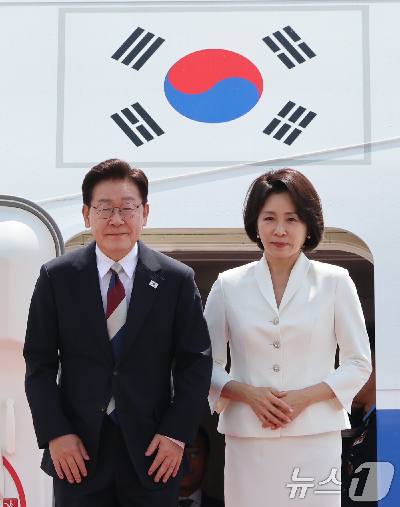 본문 이미지 - 주요 7개국(G7) 정상회의 일정을 마친 이재명 대통령과 김혜경 여사가 18일 경기 성남 서울공항에 도착해 환영객들에게 인사를 하고 있다. 2026.6.18 ⓒ 뉴스1 허경 기자