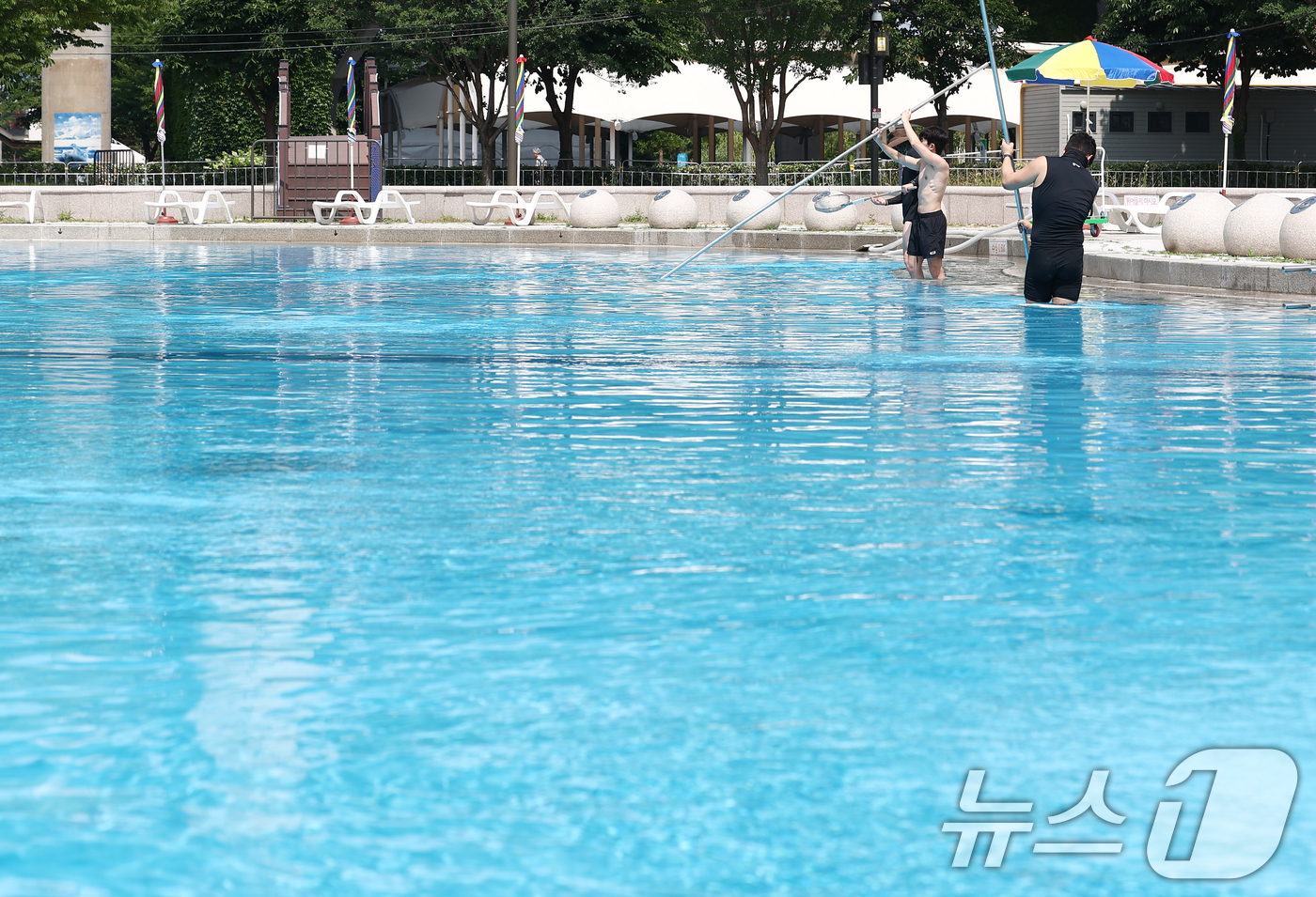 (서울=뉴스1) 김민지 기자 = 일년 중 낮의 길이가 가장 길고 밤의 길이가 가장 짧다는 절기 '하지(夏至)'를 앞둔 18일 서울 성동구 뚝섬 한강공원 수영장에서 관계자들이 개장을 …